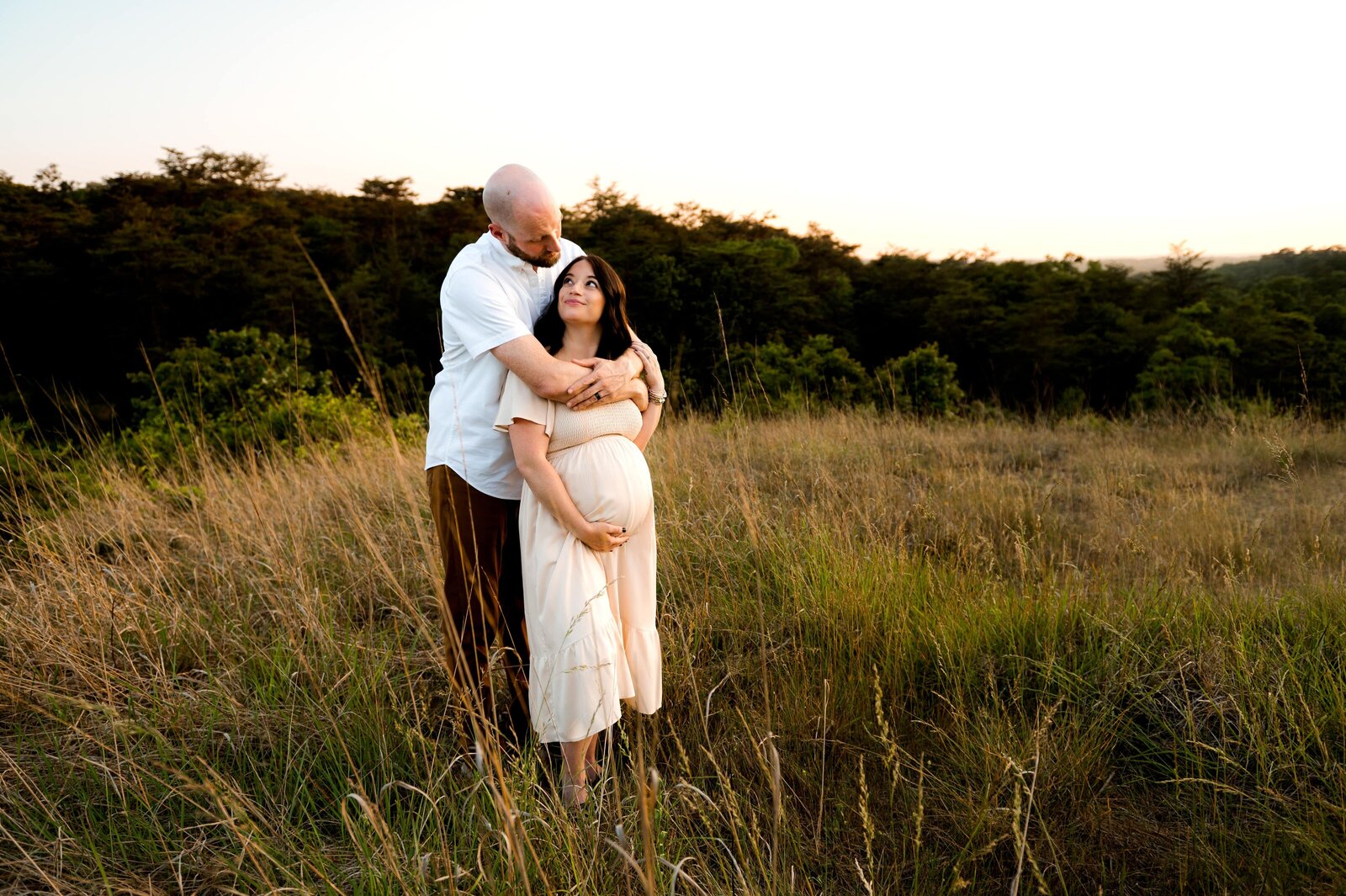husband and pregnant wife in a field