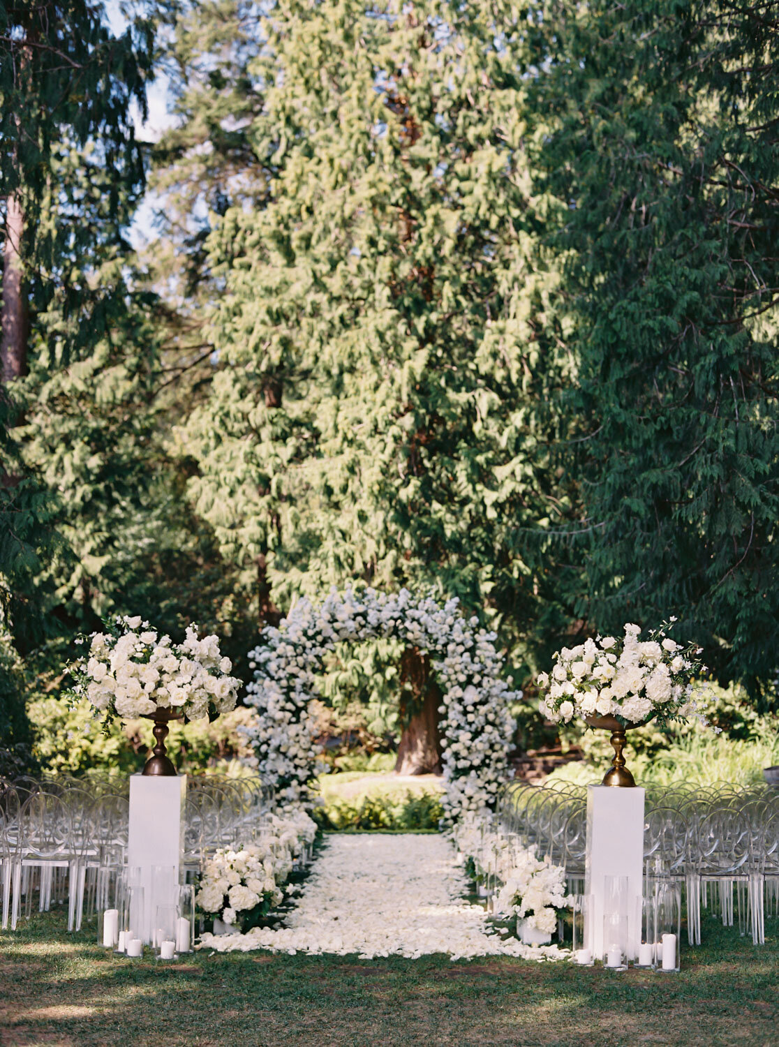 Ceremony setup featuring a floral arch and greenery