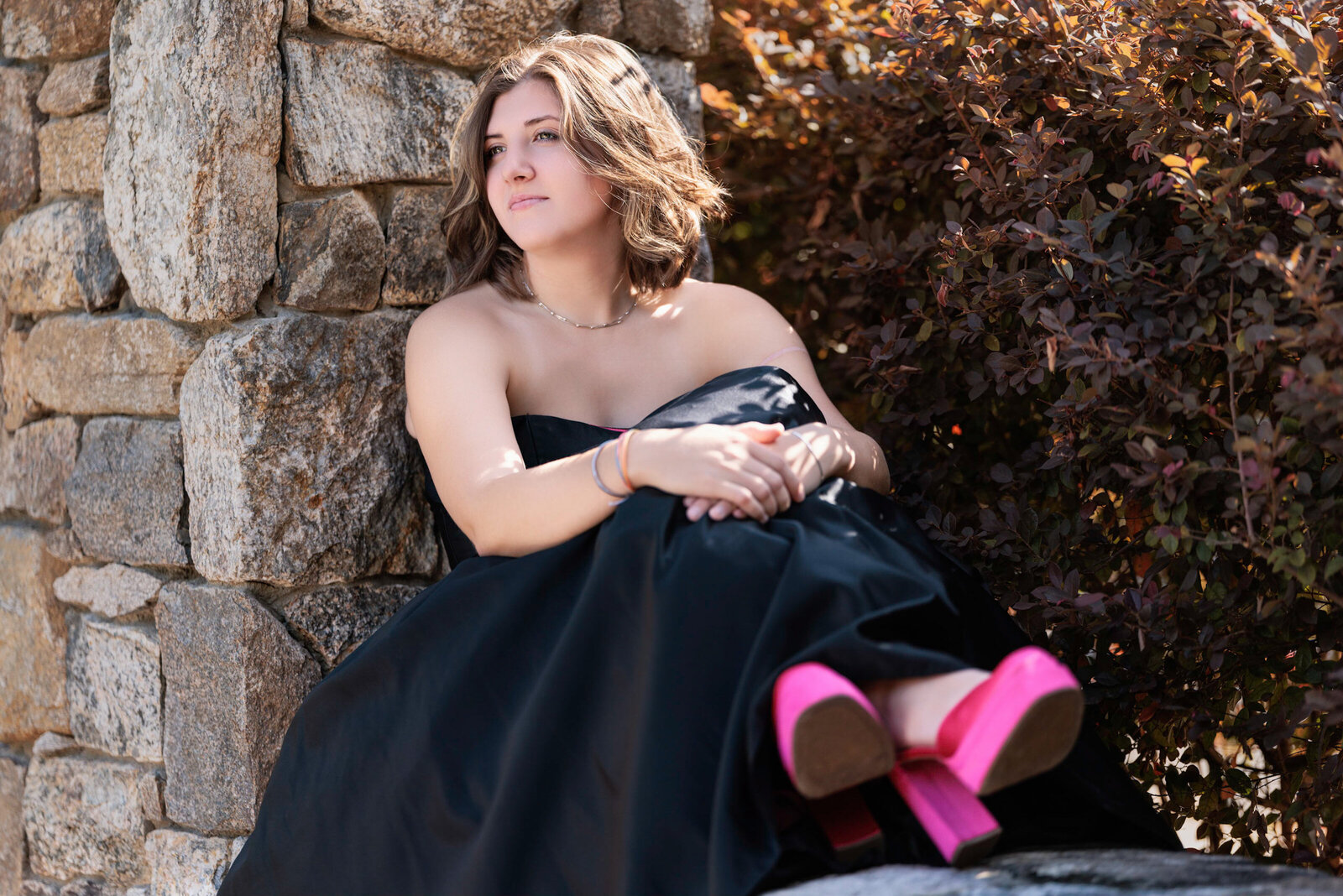 Girl outdoors sitting in black dress