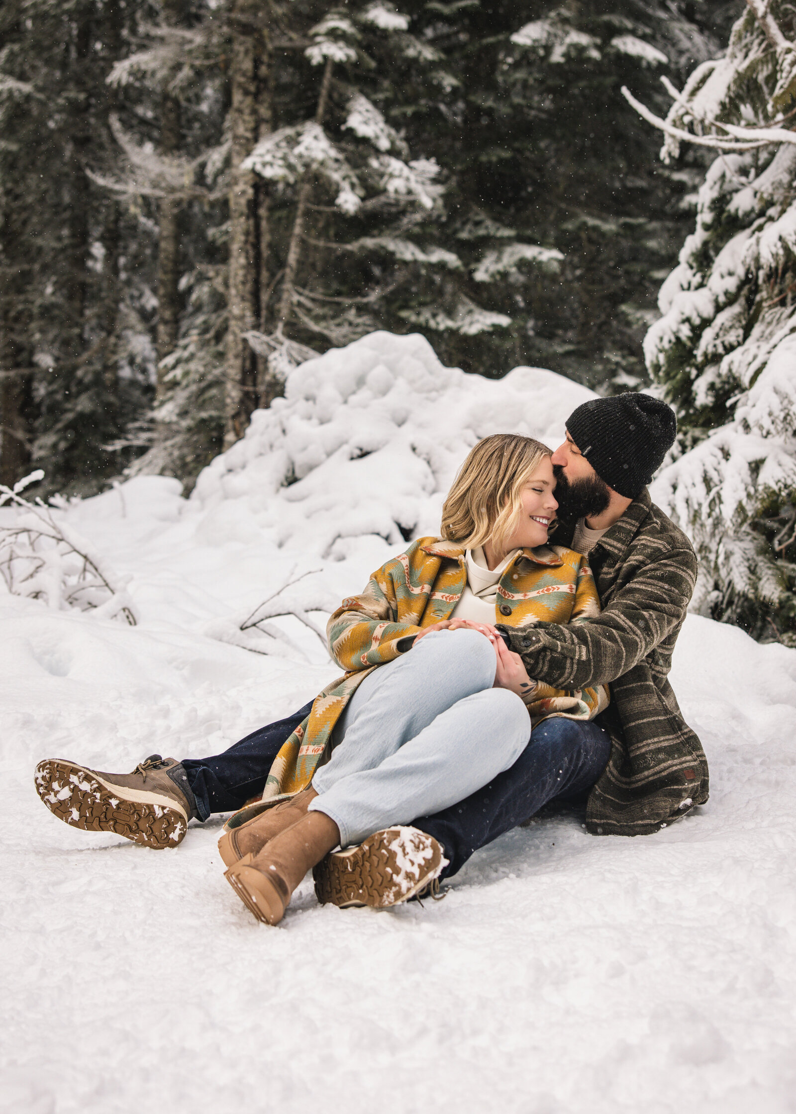 Couple snuggling in the snow on Mount Hood
