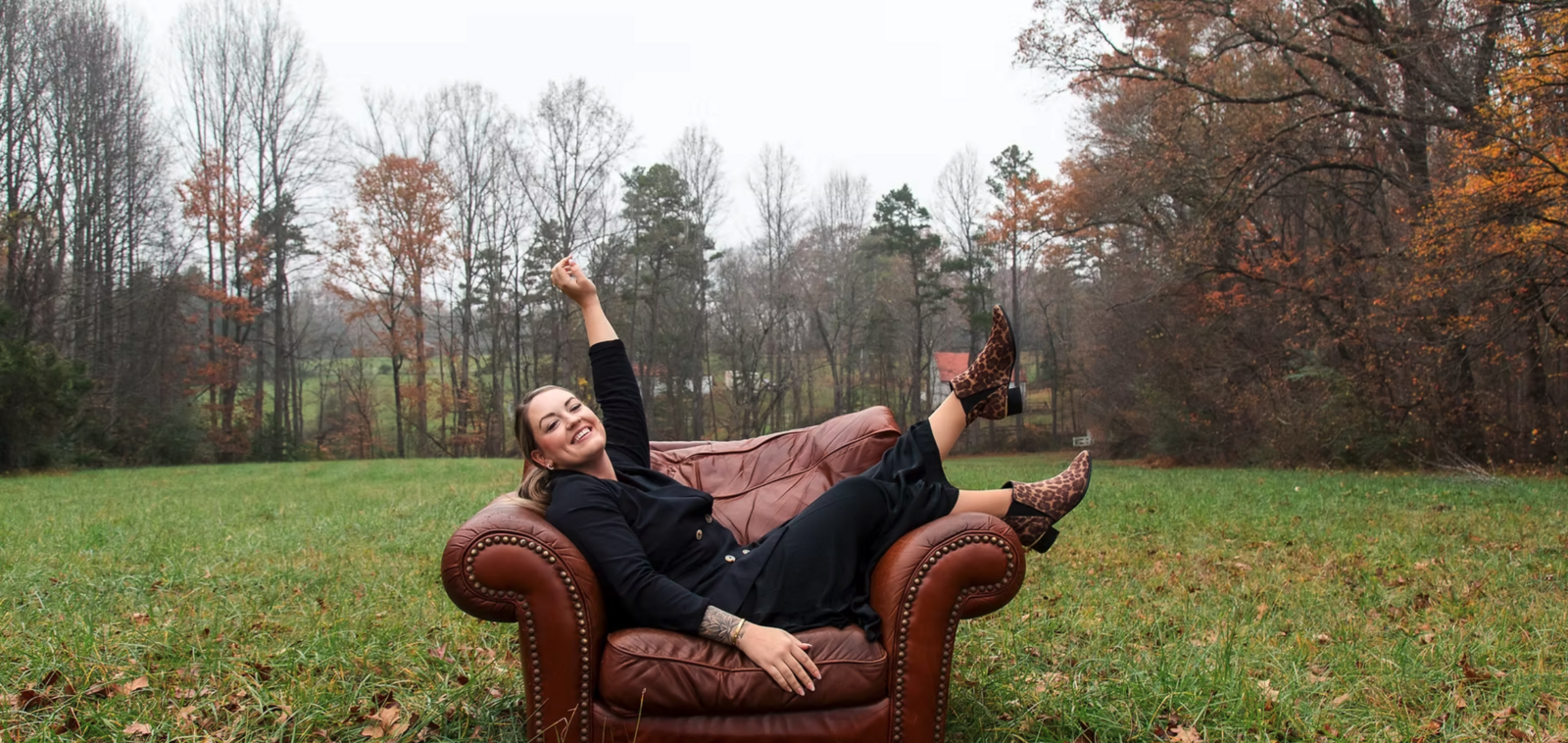 leather chair outdoors with woman laying across it