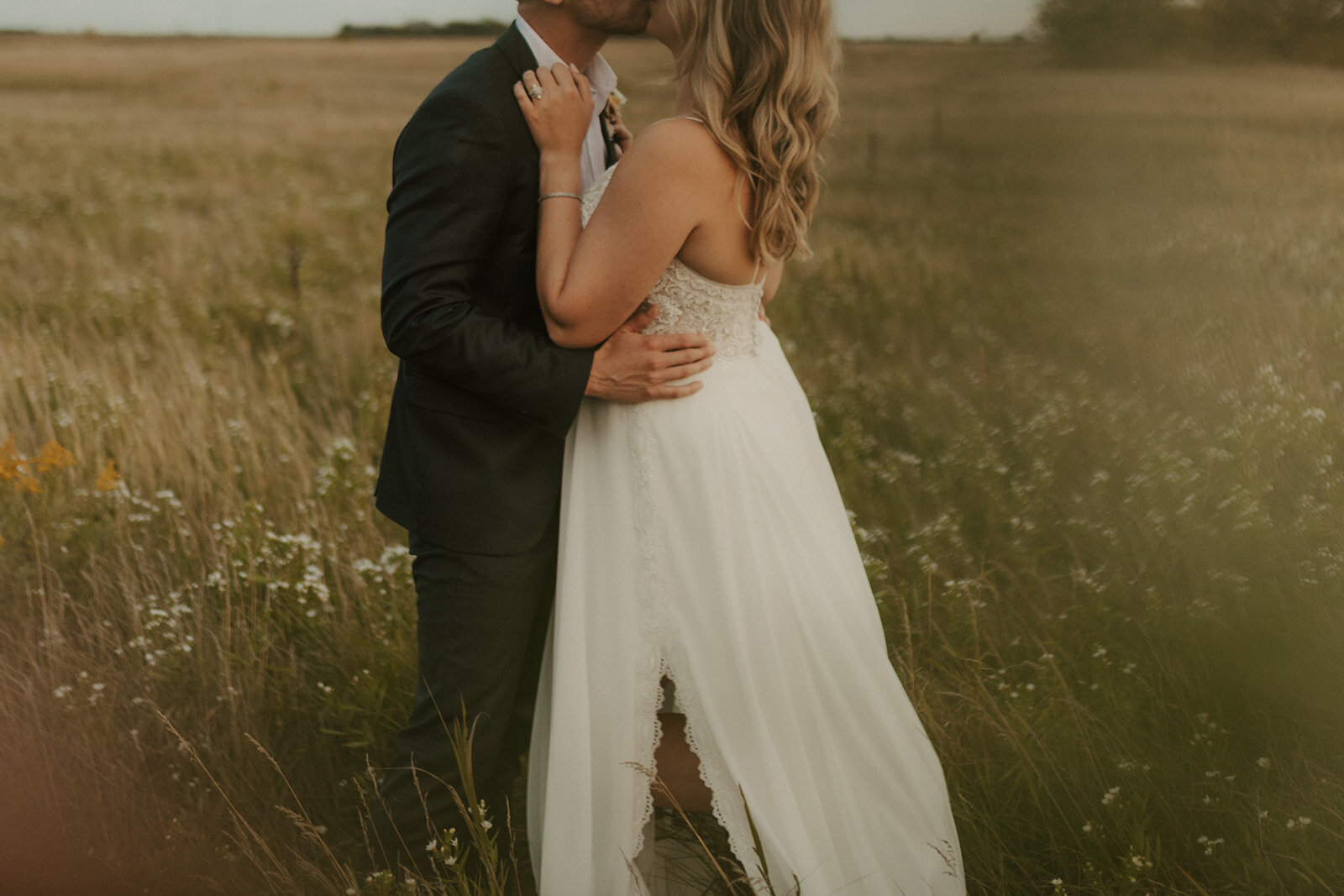 bride and groom  embracing in a field