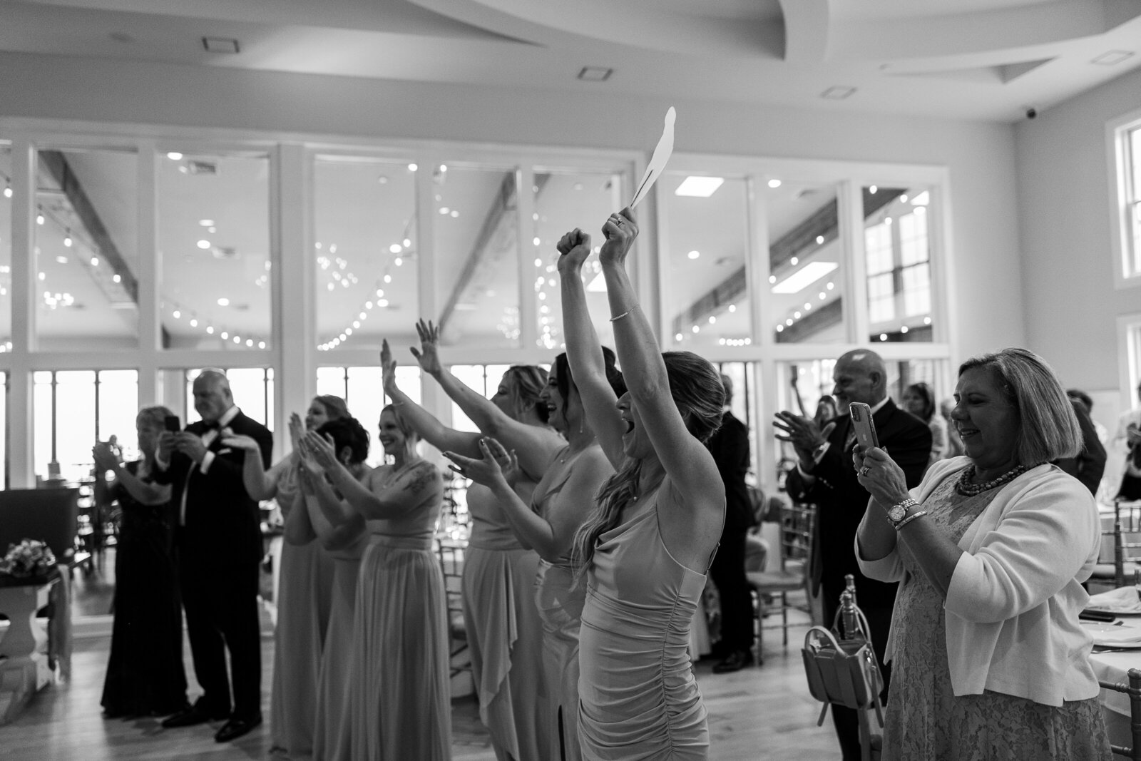 Black and white candid of wedding guests dancing and celebrating at SkyView Golf Club