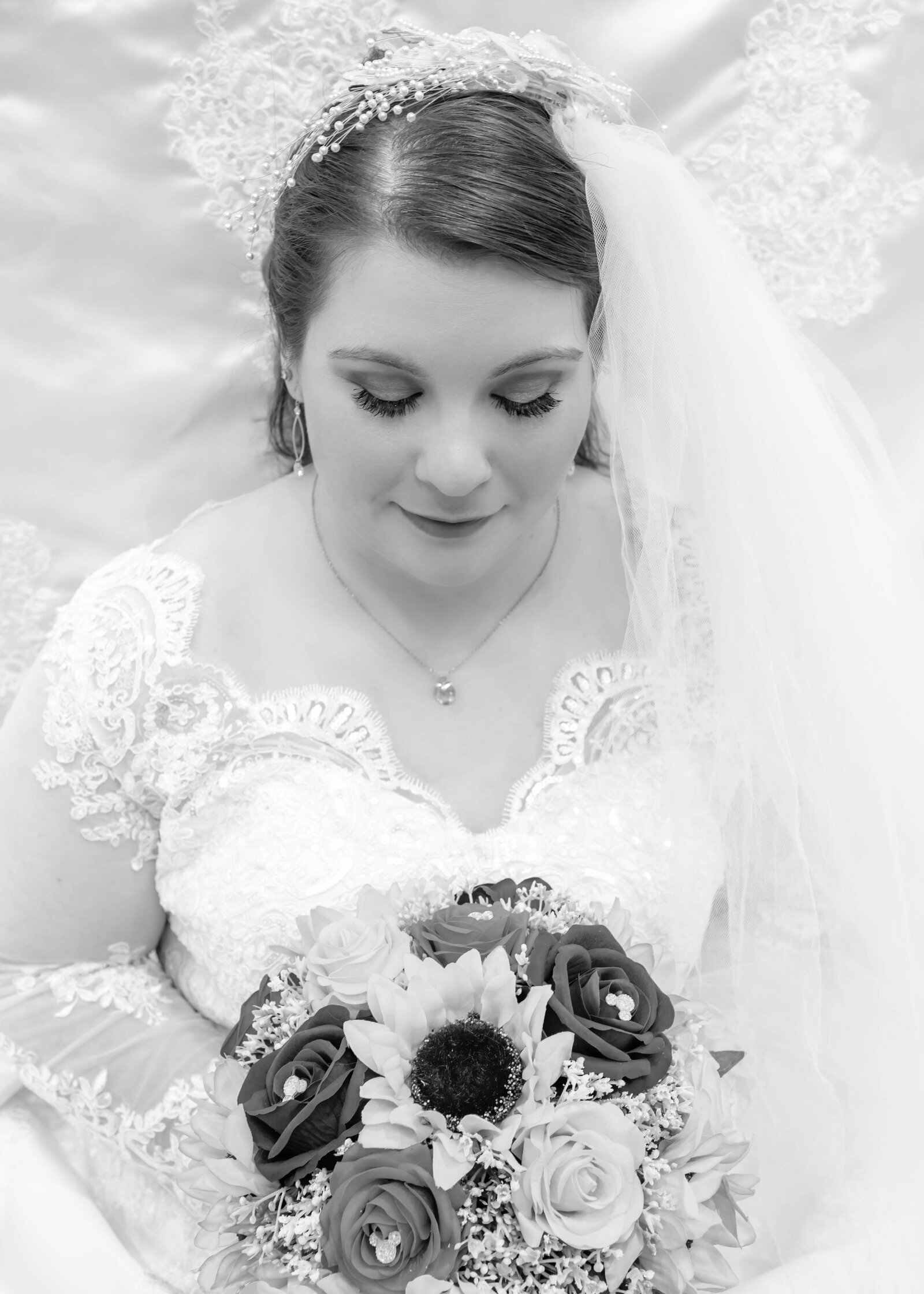 Bride with a beautiful bouquet of roses and sunflowers, captured in soft black and white, showcasing her elegance and anticipation at Duplin Winery in Wallace, NC.