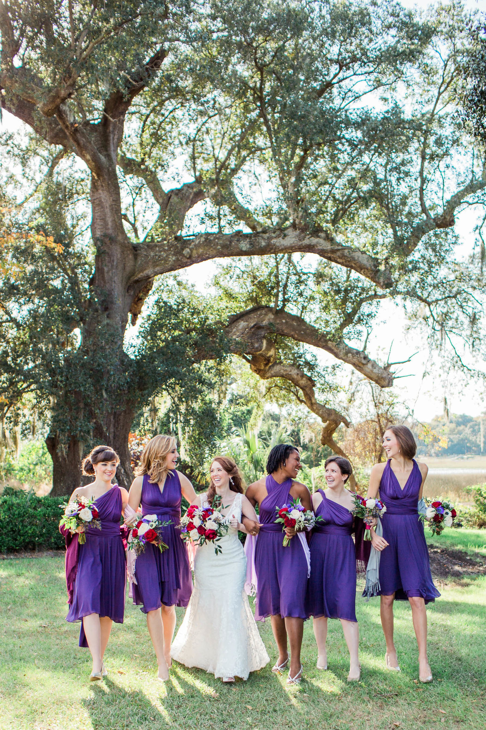 Bride and bridesmaids walk by oak tree, Boone Hall Plantation, Charleston, South Carolina