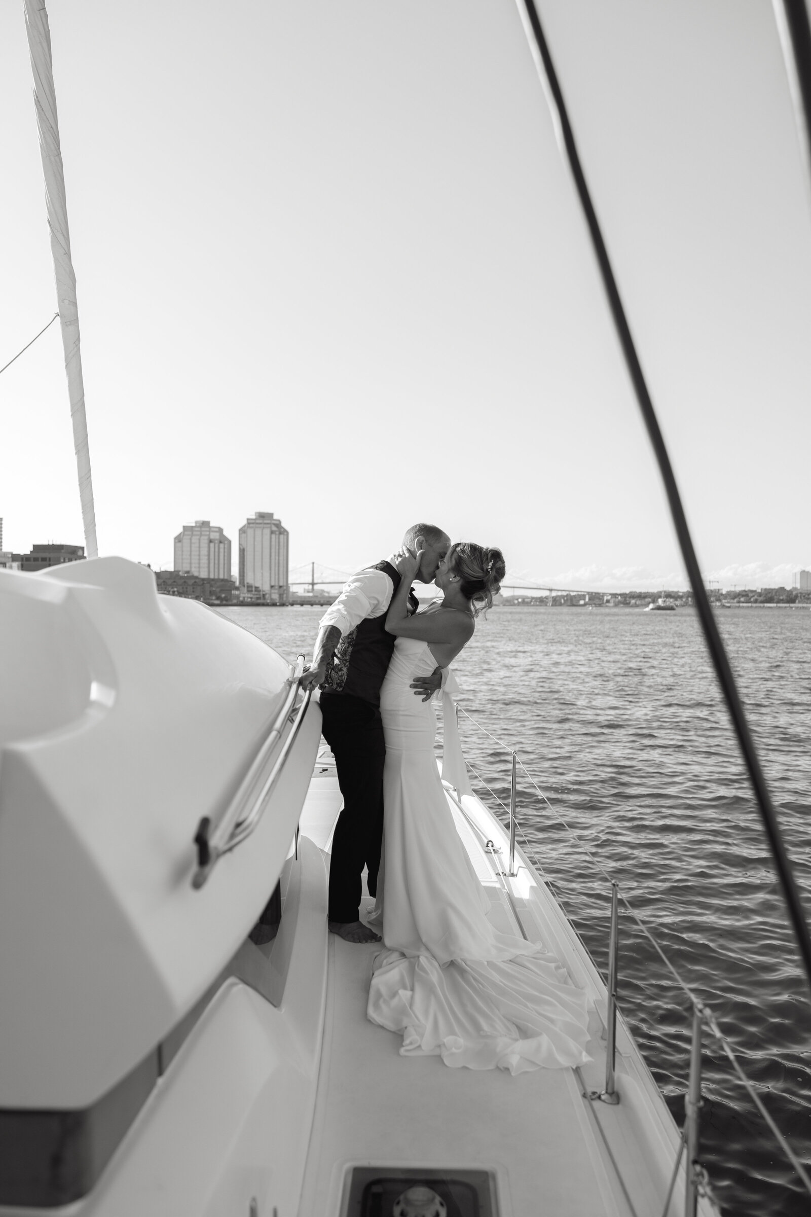 A bride and groom kiss on the deck of a boat after eloping on a catamaran in the Halifax harbour. 
