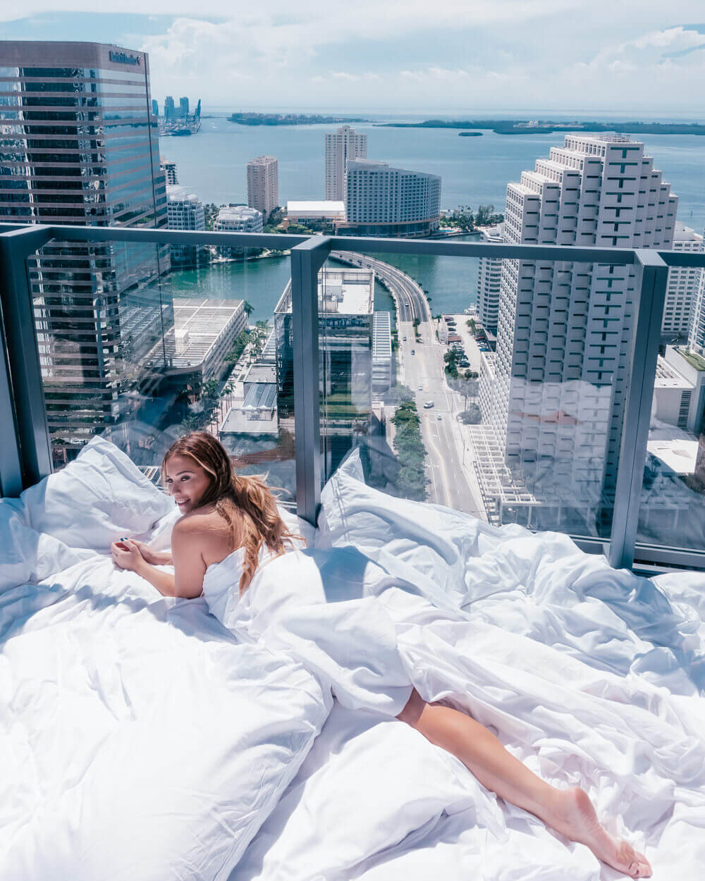Digital content creator - Isabella laying on balcony overlooking city and ocean