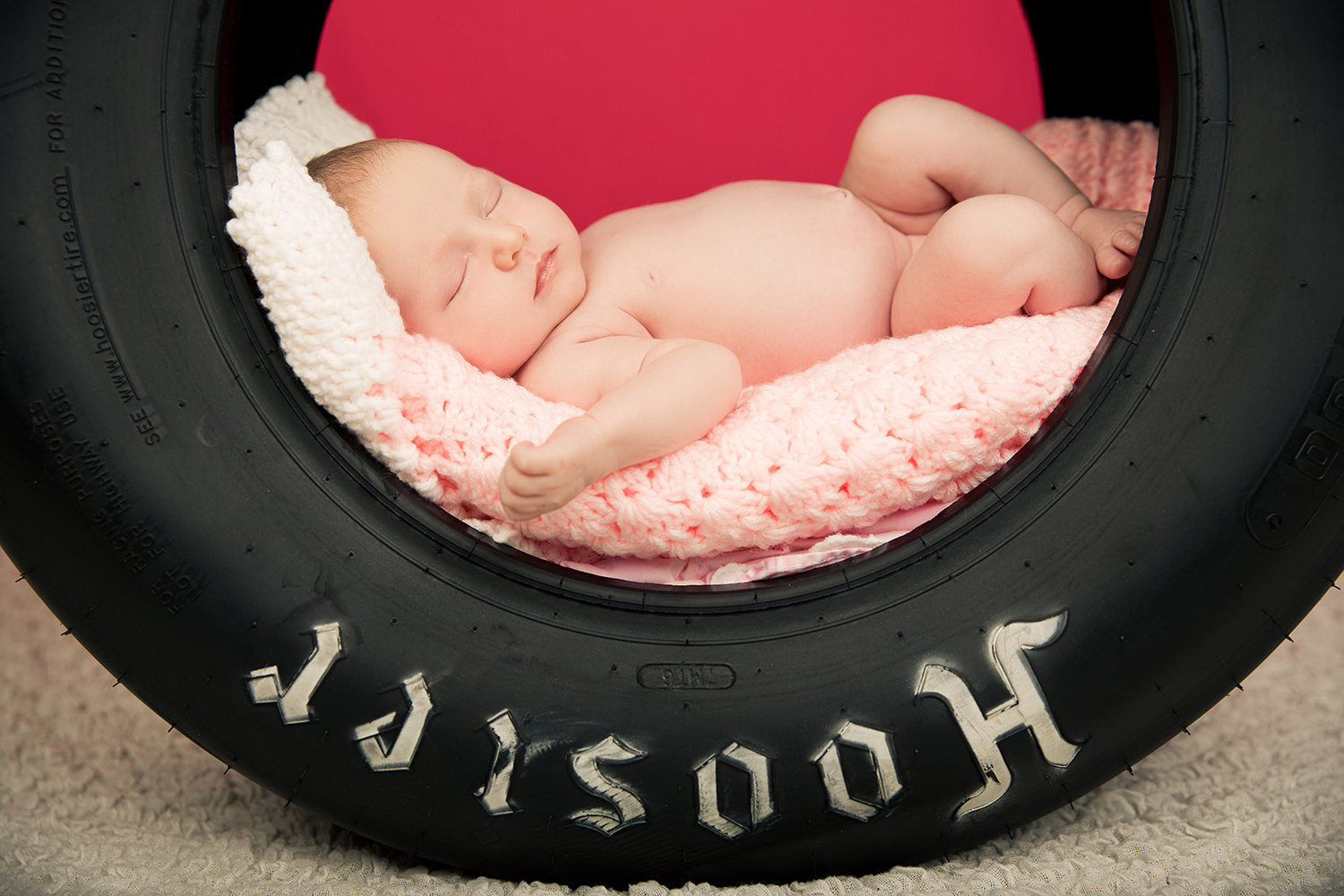 san diego newborn photography | newborn laying in tire with pink blanket