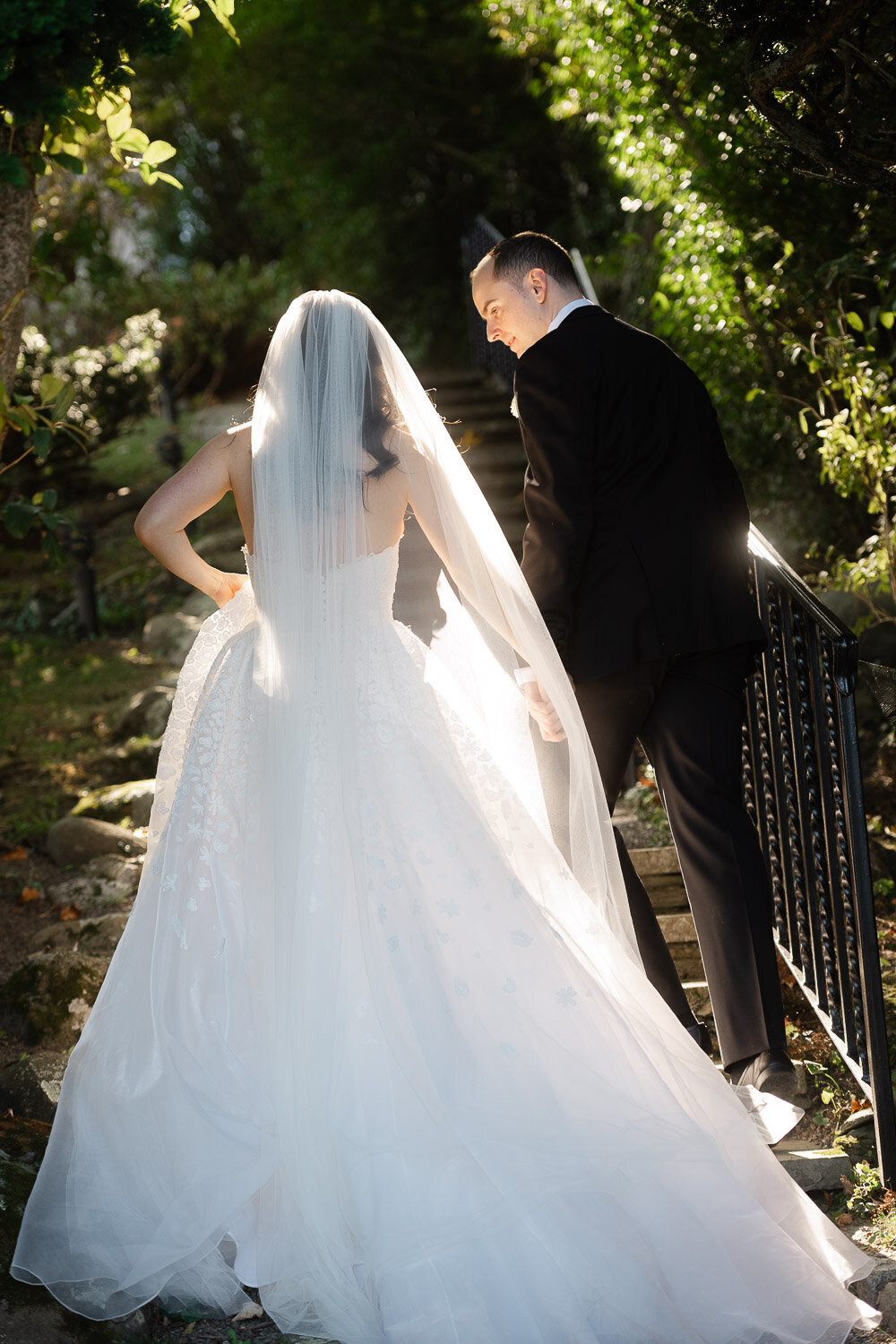 bride and groom walk up stairs in sinlight