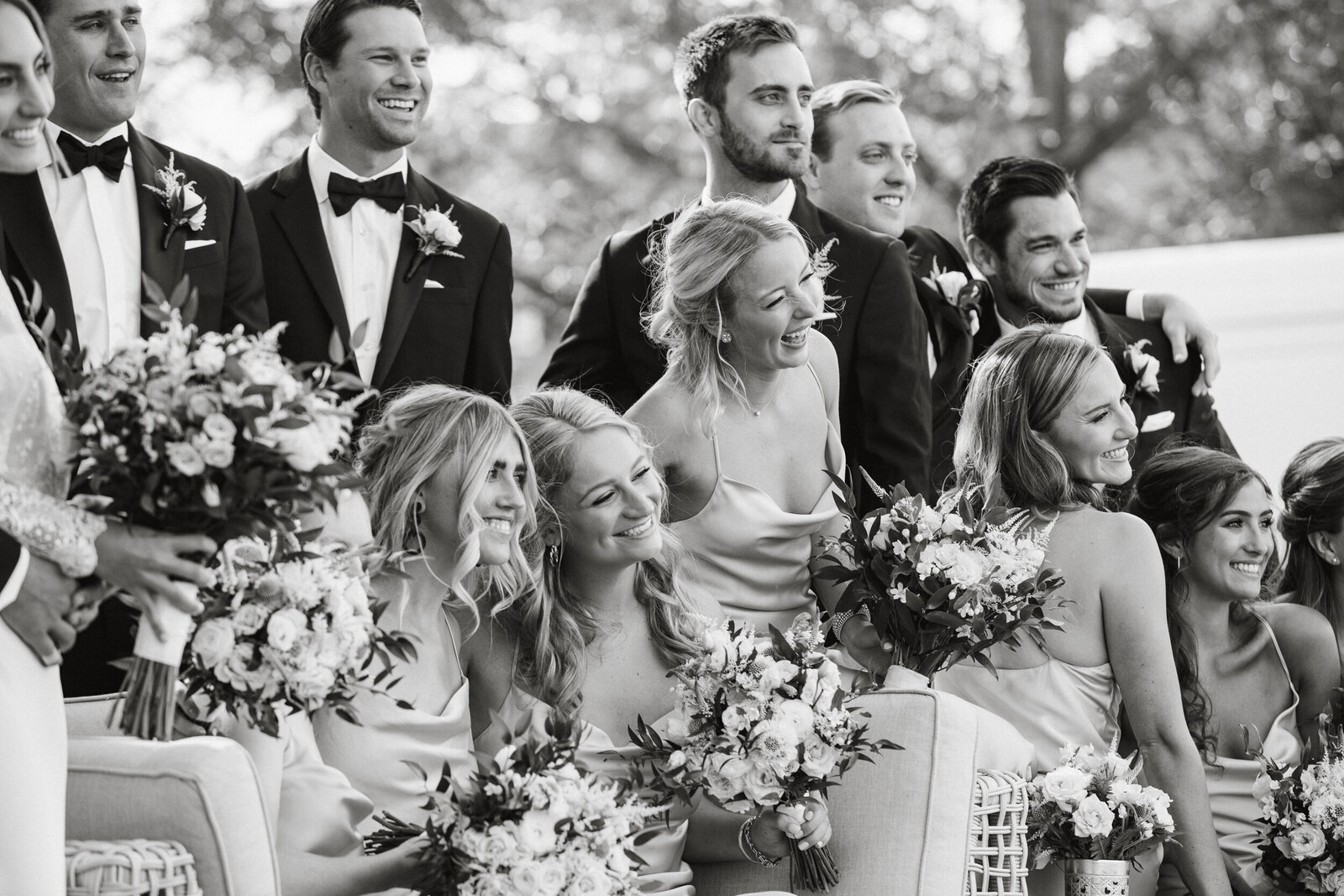 Couple laughing with bridal party during portraits at Radnor Hunt Landing wedding. 