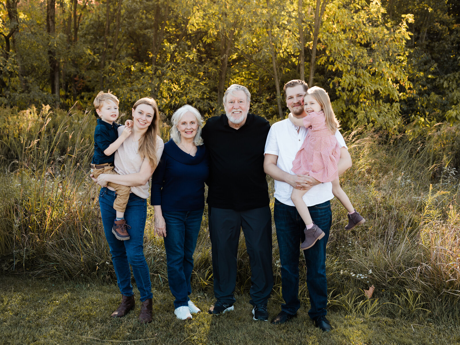 parents, grandparents and two children posed at park for family photos