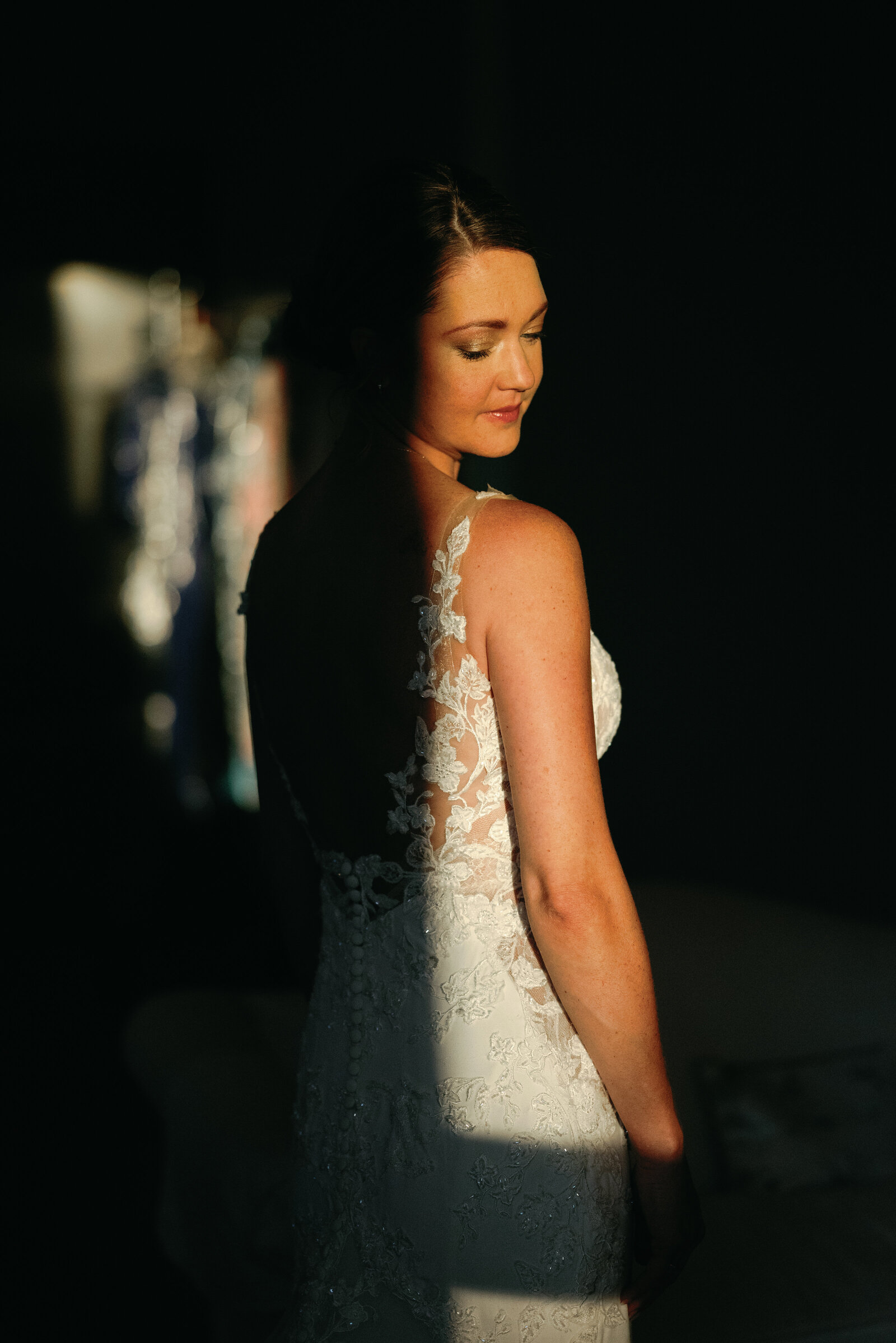 dramatic lighting showing only half of the bride as she waits for the ceremony to begin
