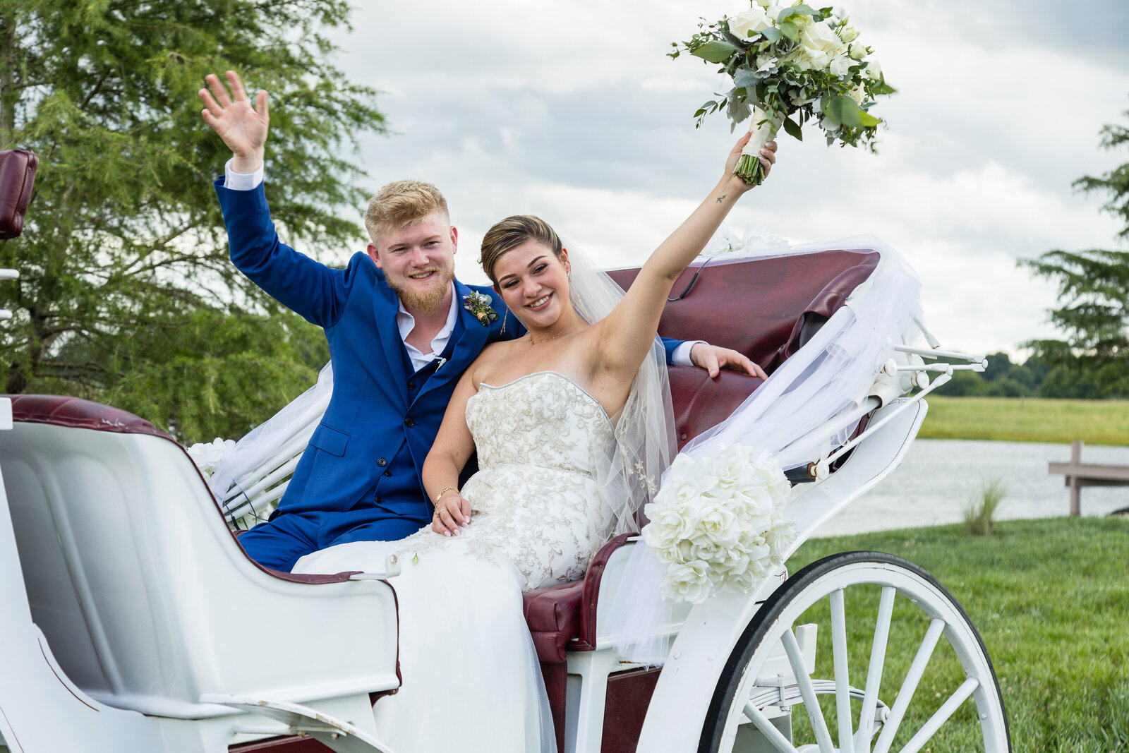 Newly married couple riding away  in horse drawn carriage