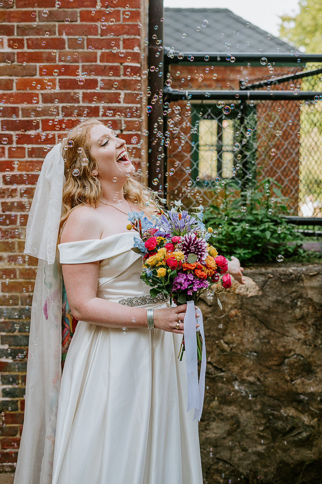 laughing happy bride with bright bouquet