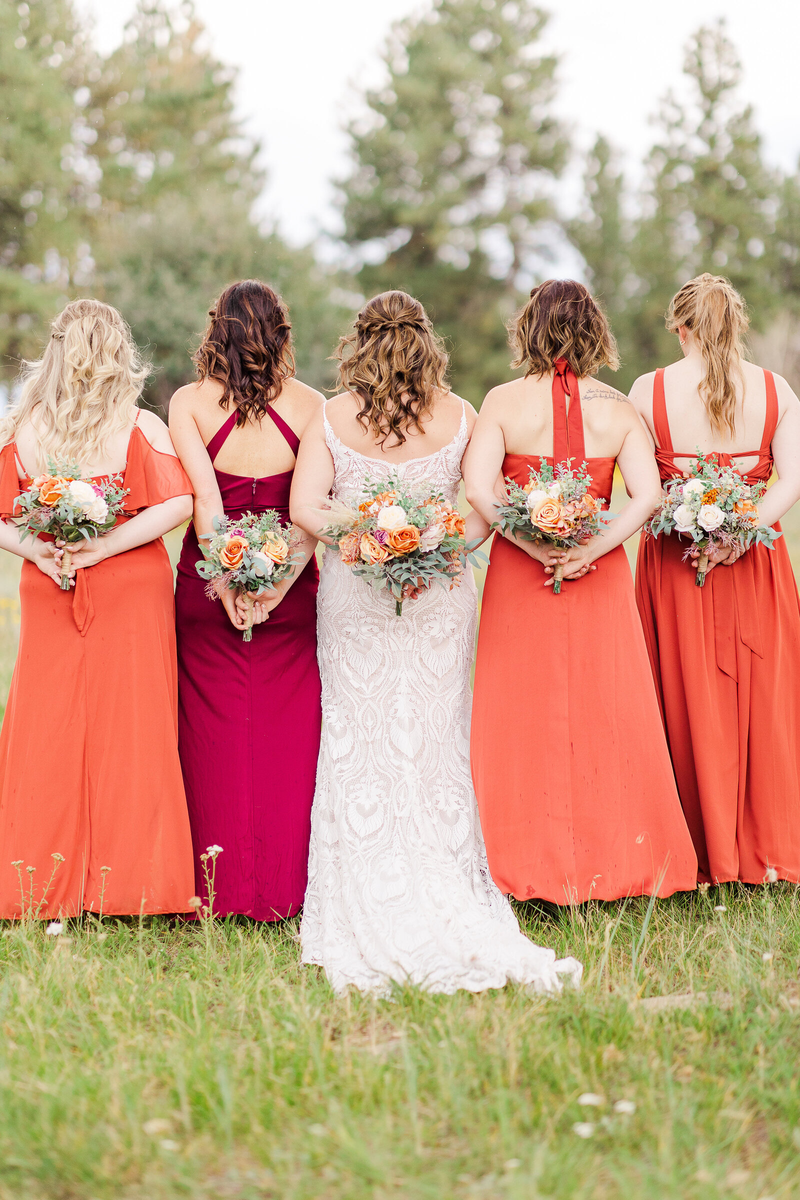 Back shot of bride and bridesmaids with bouquets