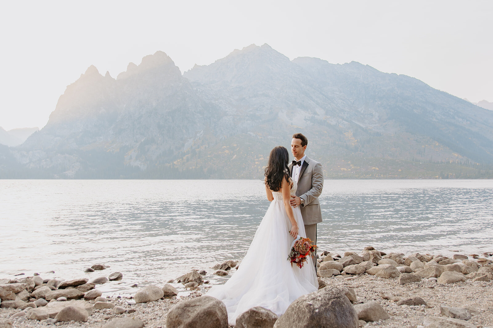 Couple looks at each other during Wyoming elopement photos by  jenny lake