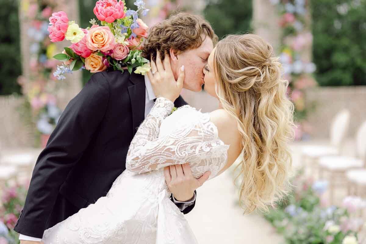 photo of bride and groom kissing in classing leaning pose