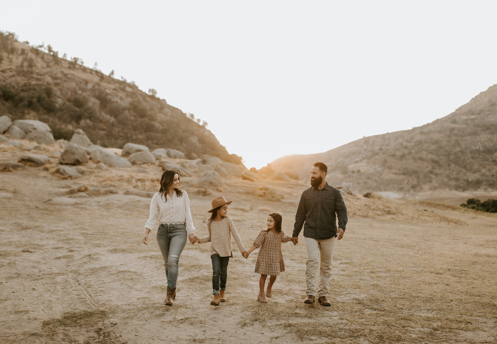 Family holding hands walking through the desert