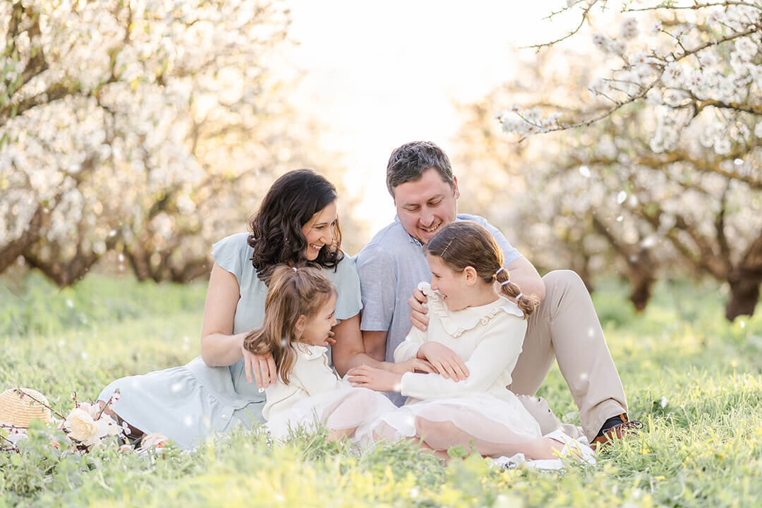 family of 4 snuggling close outside at sunset during their intimate family session in Brisbane