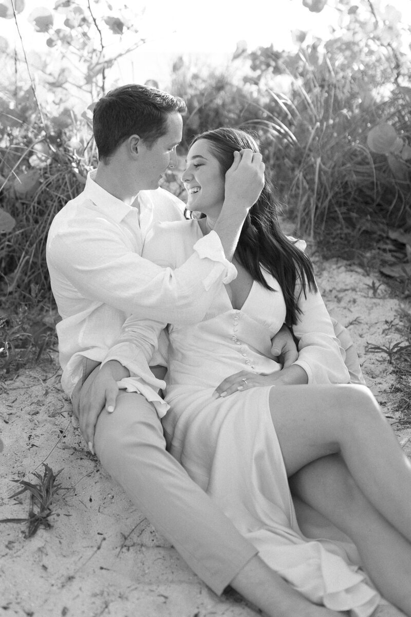 couple hugging and embracing while sitting on Naples Florida beach