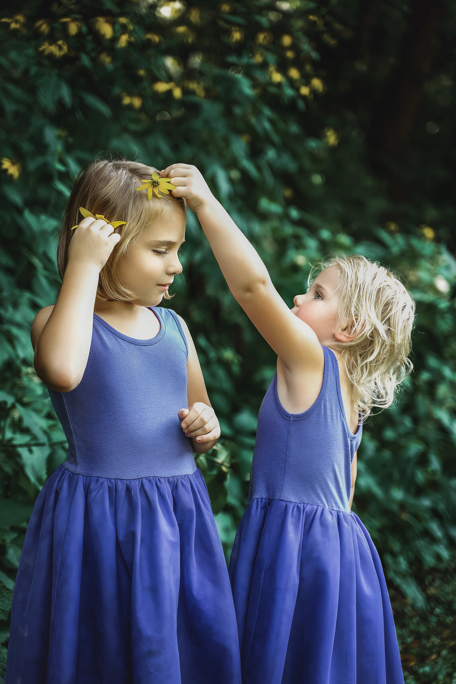 Two girls putting yellow flowers in their hair