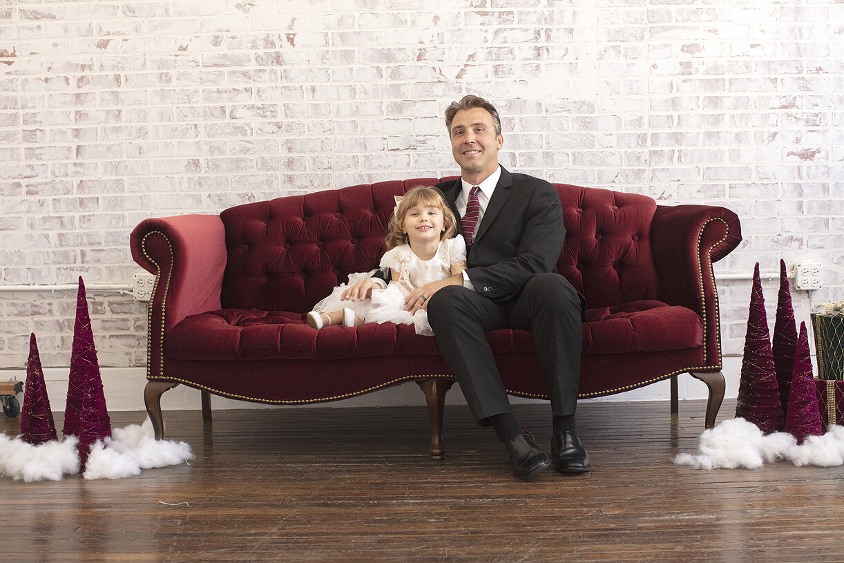 Father and daughter pose on couch in Dallas photography studio