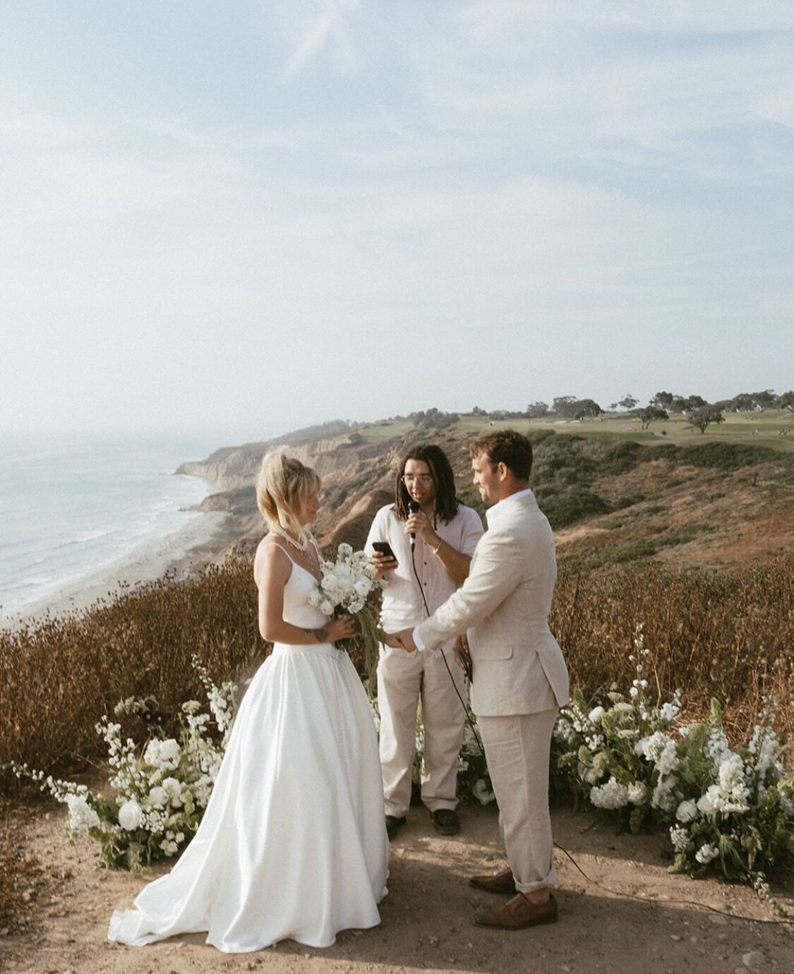 Bride and groom at intimate cliffside ceremony overlooking the ocean planned by Jasper & Lane Events