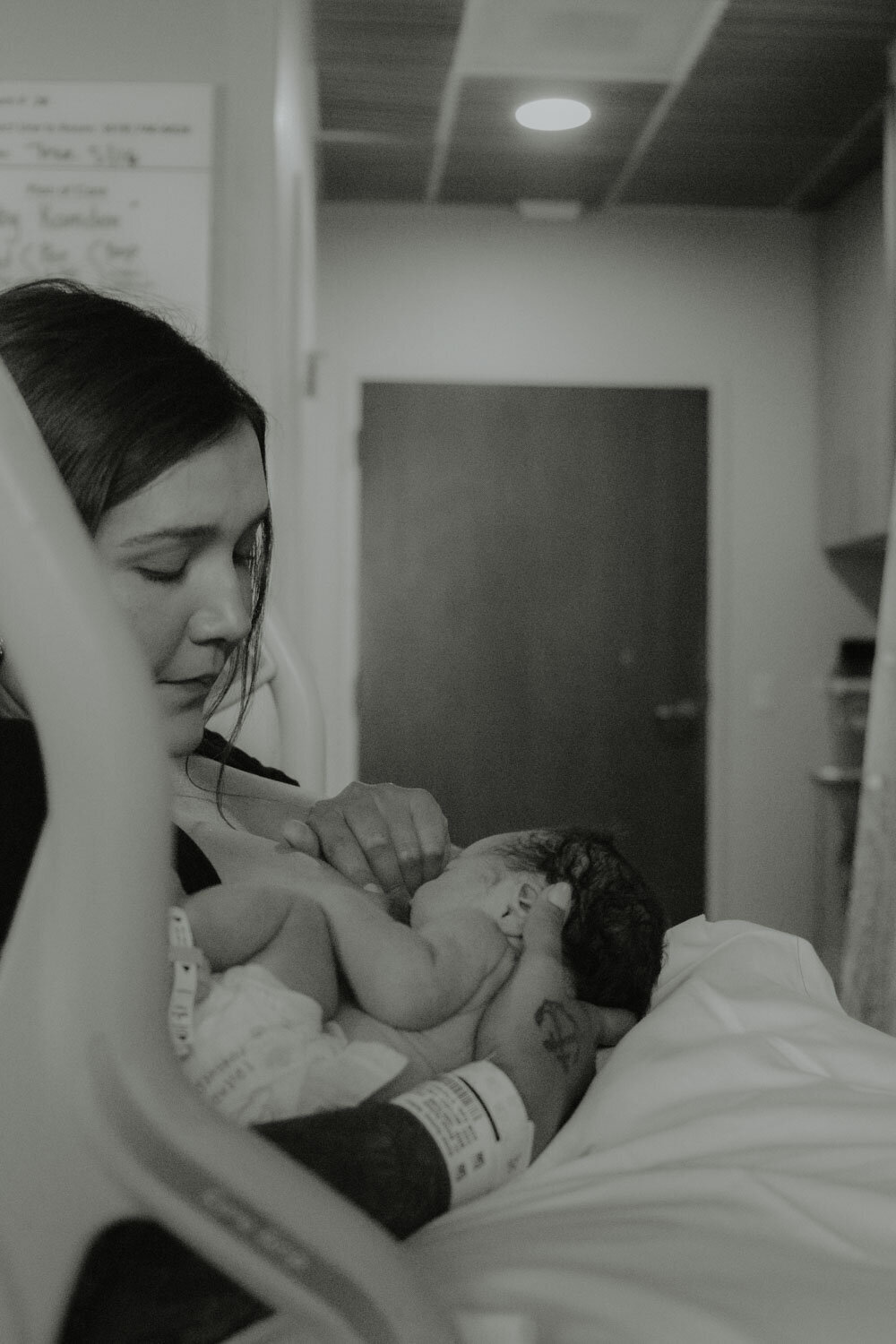 Black and white photo of a mother breastfeeding her newborn in the hospital