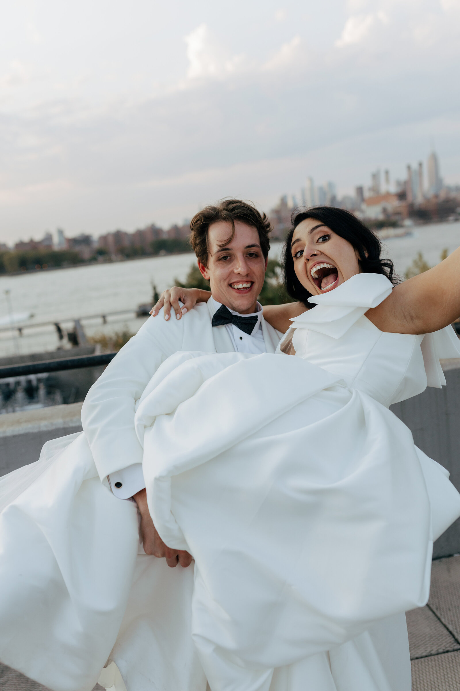 Groom holding bride high in front on the New York Skyline | Emma LeeAnn Photography
