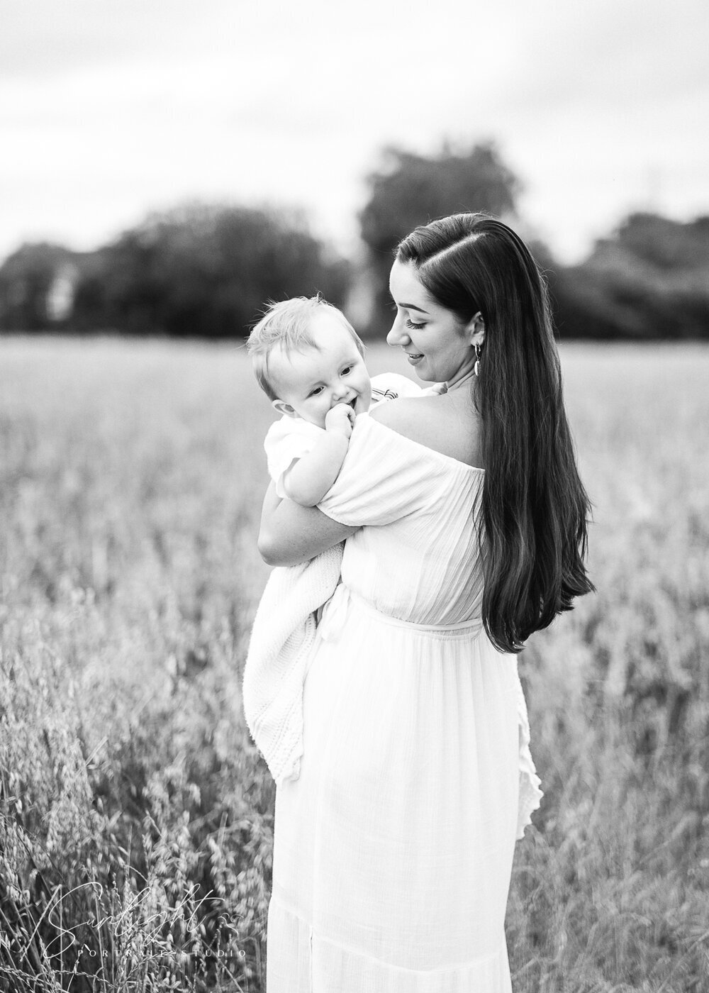 Older baby photography in Bristol fields as woman holds baby