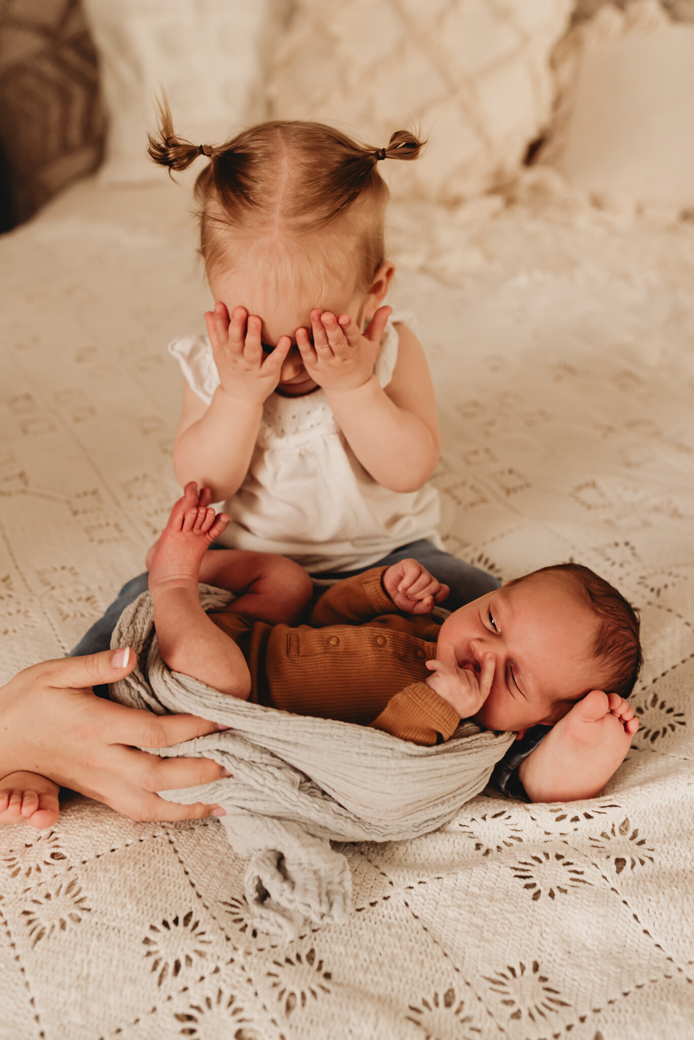 Big sister isn't quite sure about the new baby that mom and dad brought home and Nikii was there to capture this cute little moment between new siblings in her downtown bismarck studio