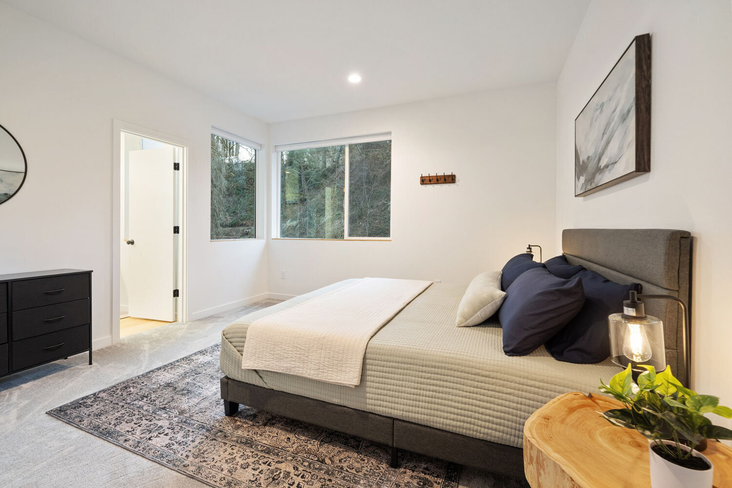 A cozy modern bedroom with a grey upholstered bed and wooden side tables