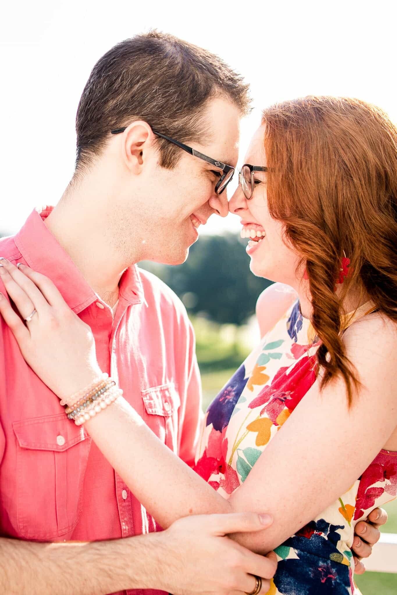 An engaged couple laughing together wearing colorful clothing during their engagement session in Northern Virginia