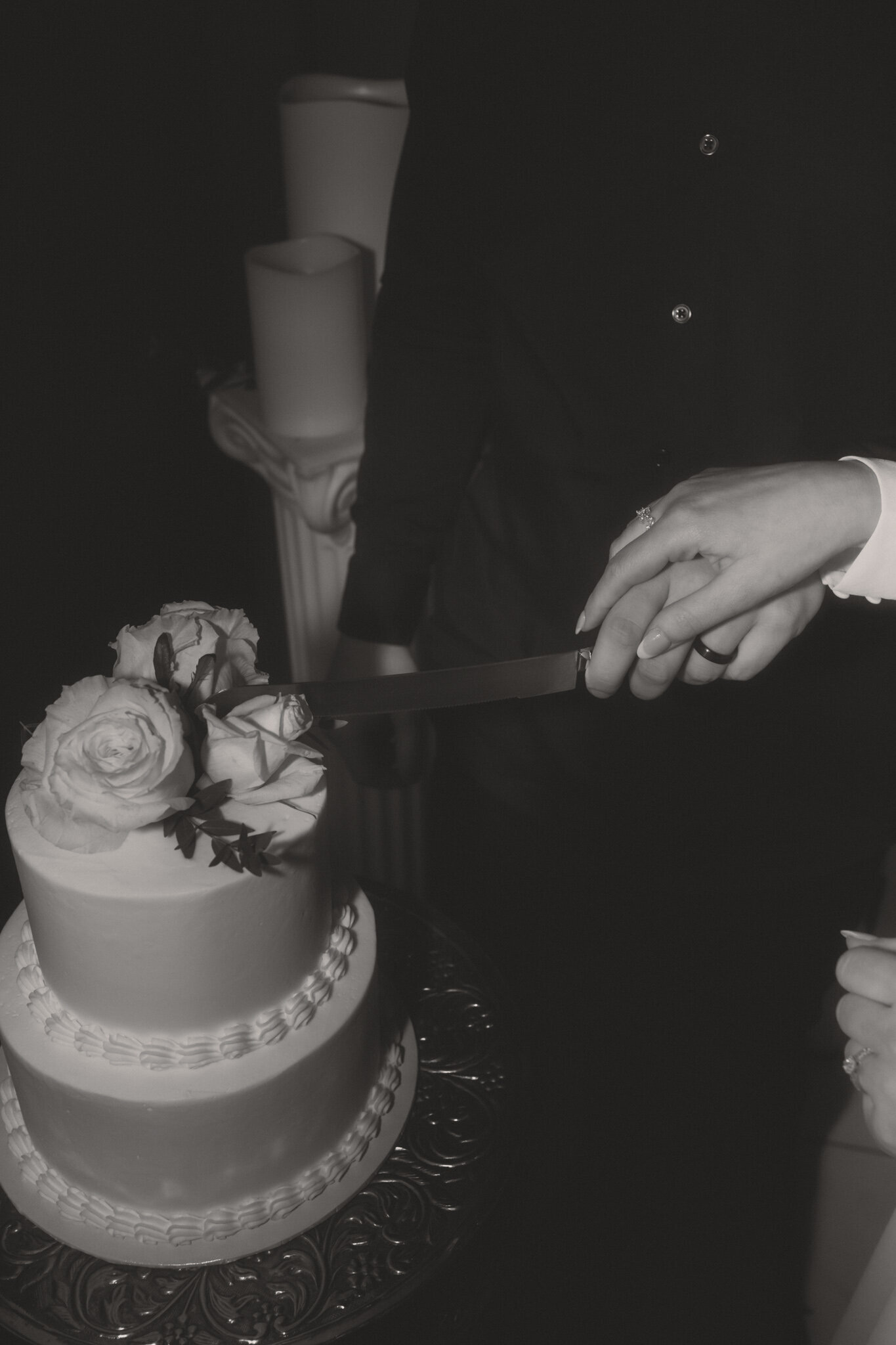 A married couple cutting into their wedding cake together.