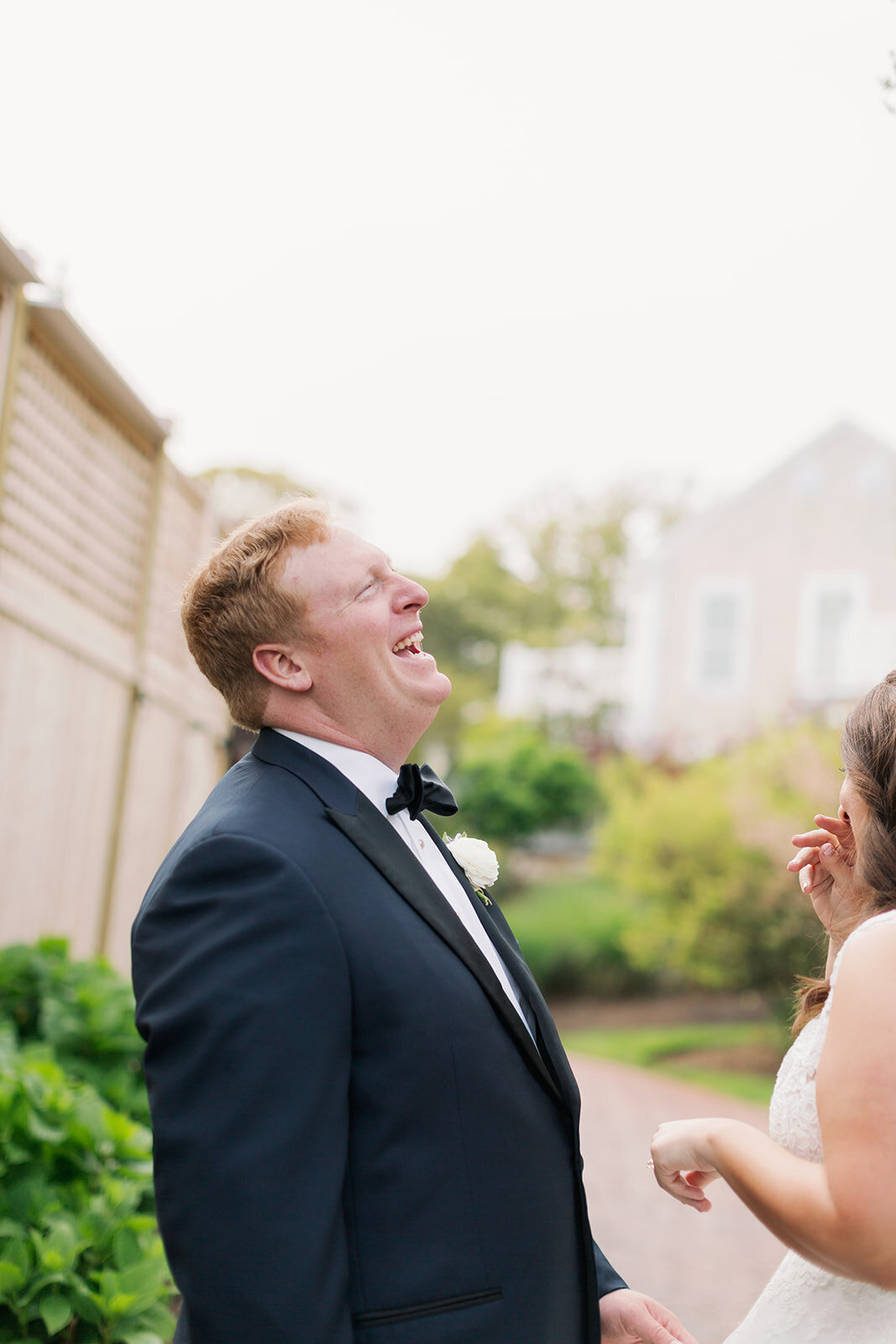 Man laughing as a bride stands in front of him.