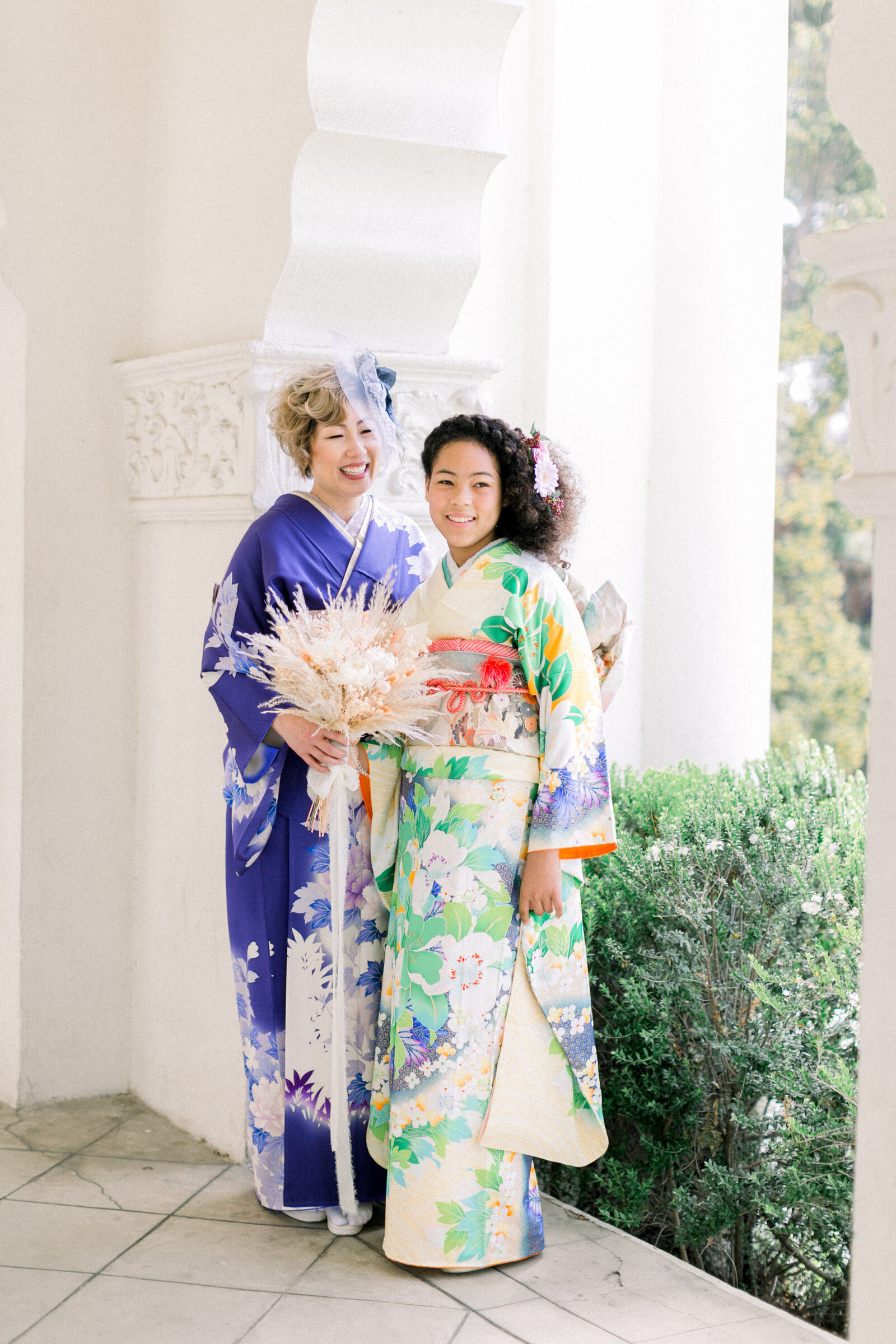 Mother and daughter smiling together in vibrant furisode kimono during Seijinshiki at Brand Park Glendale, kimono rental Los Angeles | ロサンゼルス・ブランドパークでの成人式、鮮やかな振袖姿で微笑む母娘のポートレート