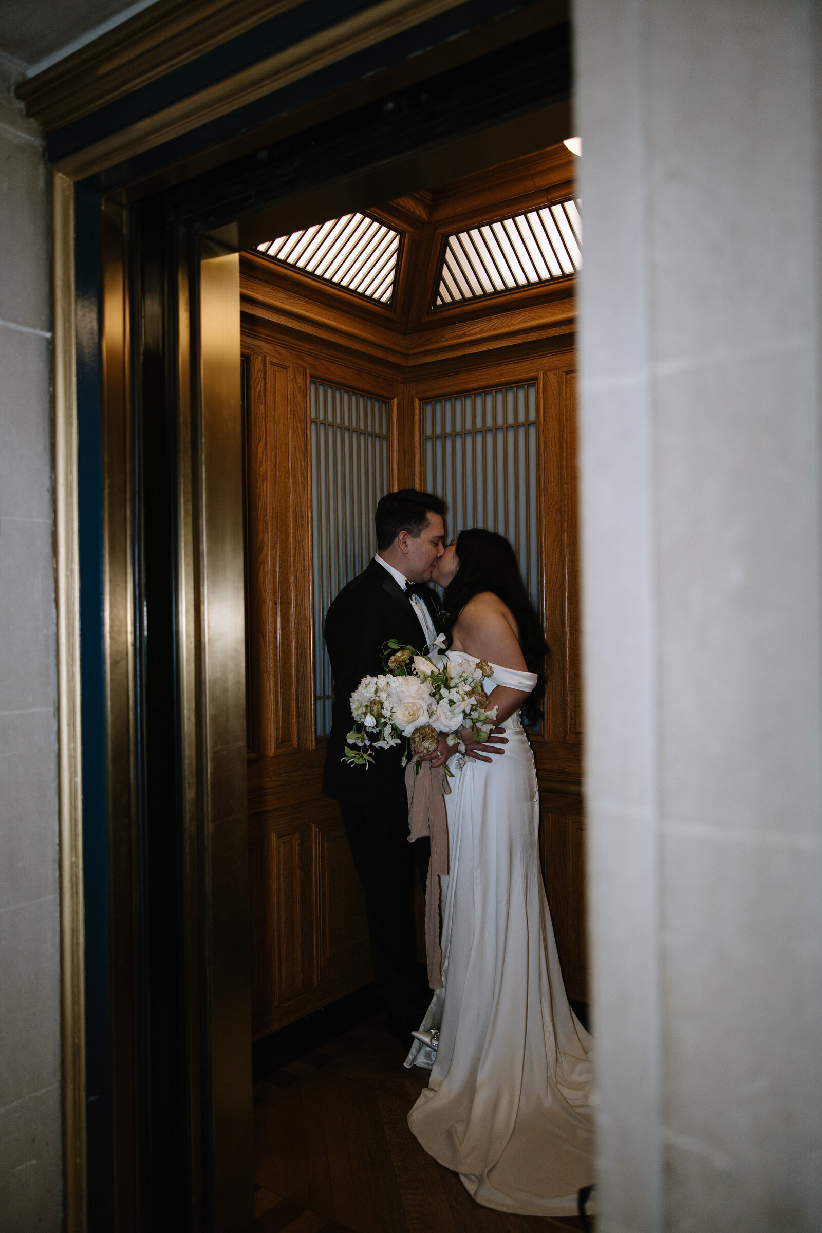 Bride and groom kiss in elevator at San Francisco City Hall elopement