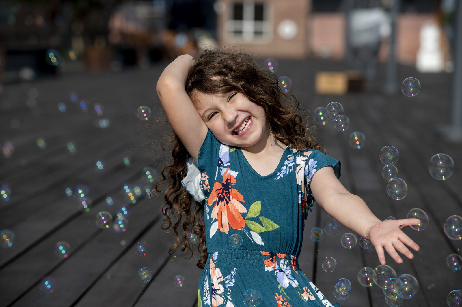 A small child laughing and playing with bubbles 