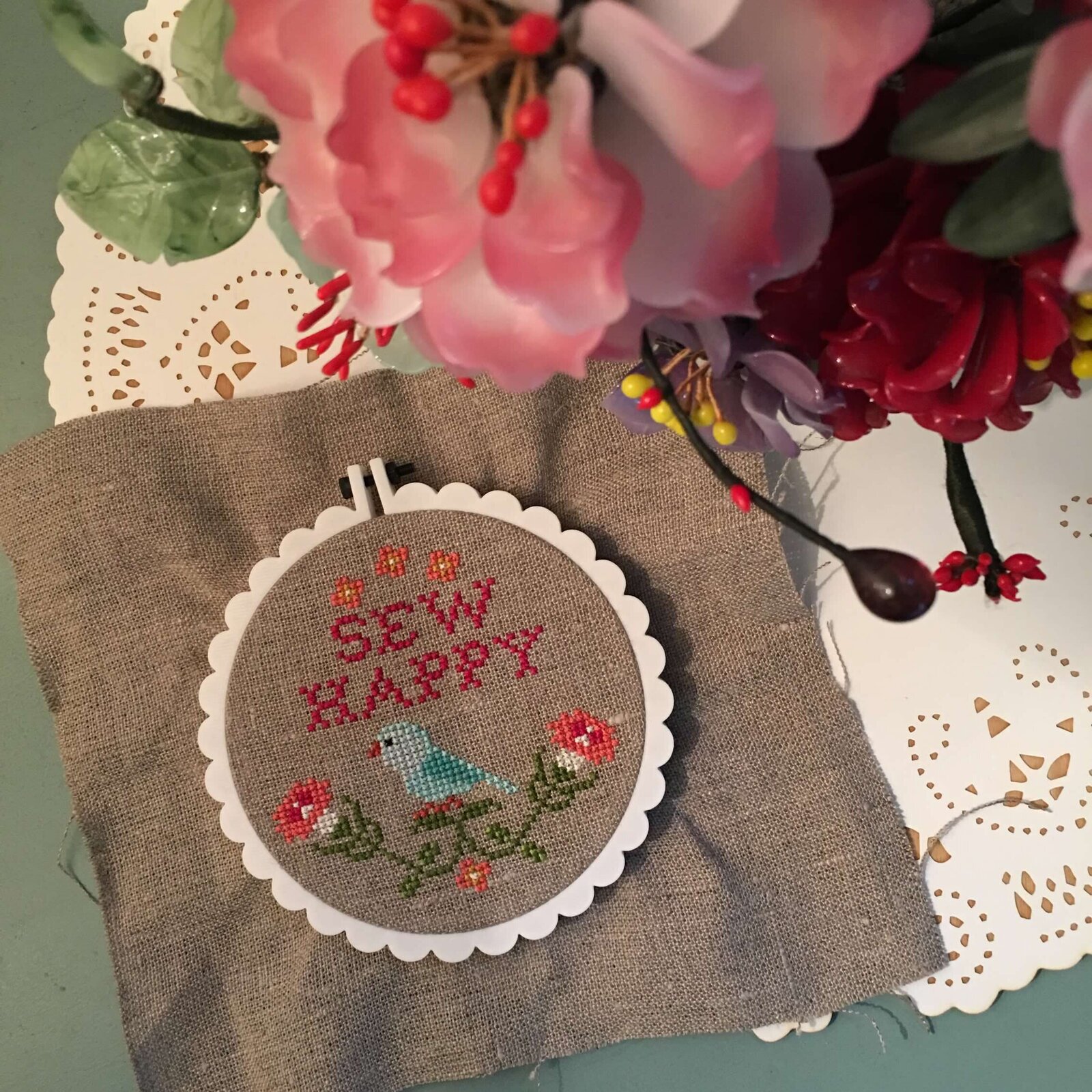 Sew Happy cross stitch design with flowers in a scalloped ring