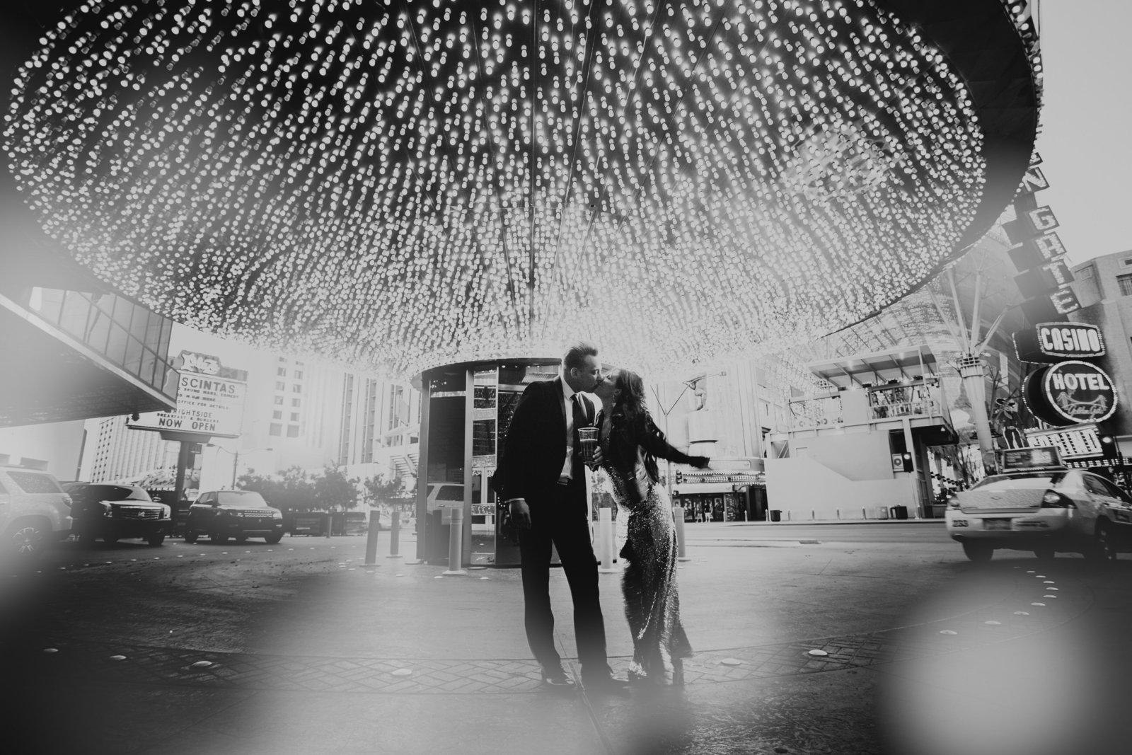 couple kisses under canopy of lights at plaza hotel on fremont street las vegas