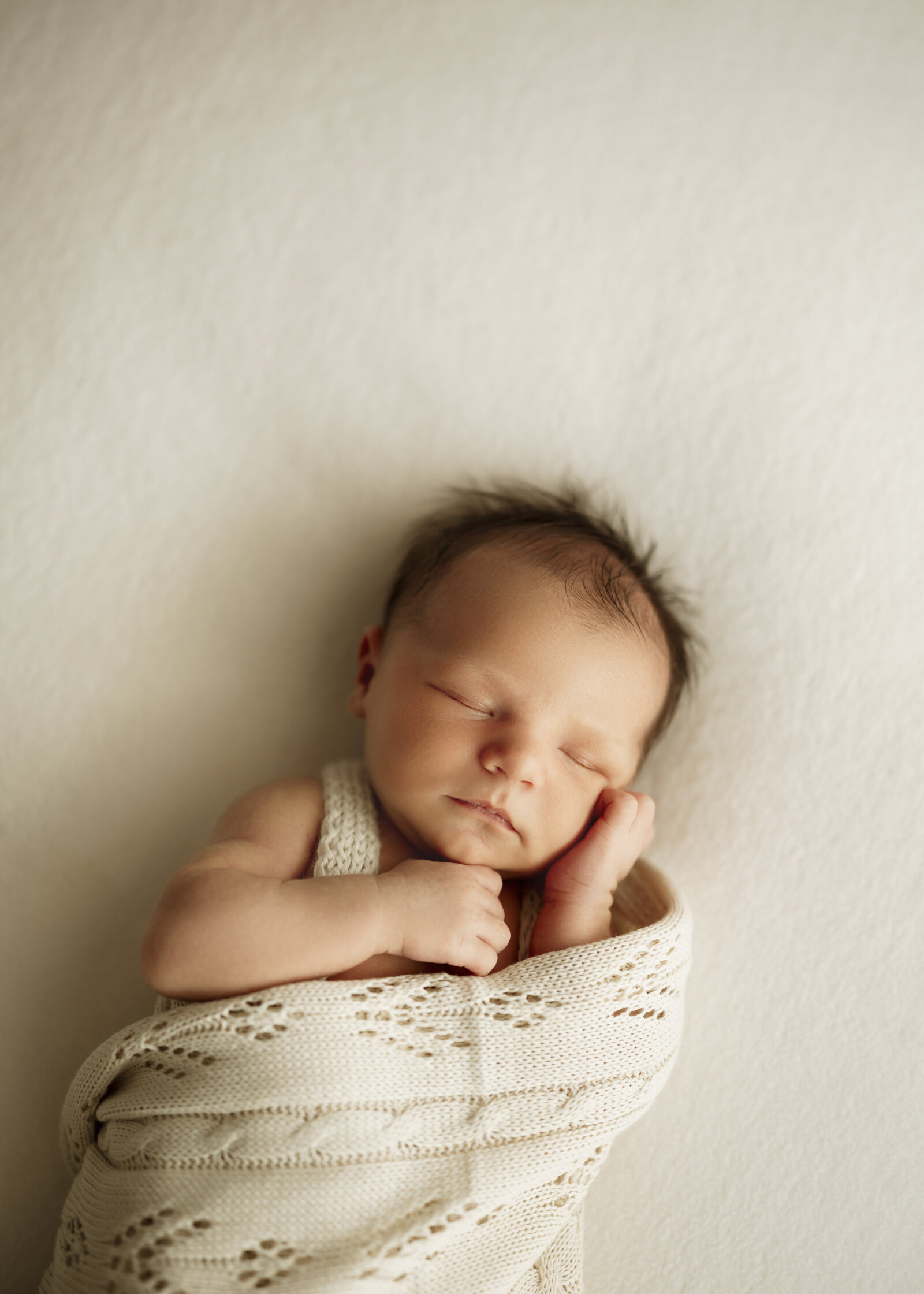 Newborn and parents studio photoshoot in Perth, featuring a timeless and loving embrace of a family with their newborn.