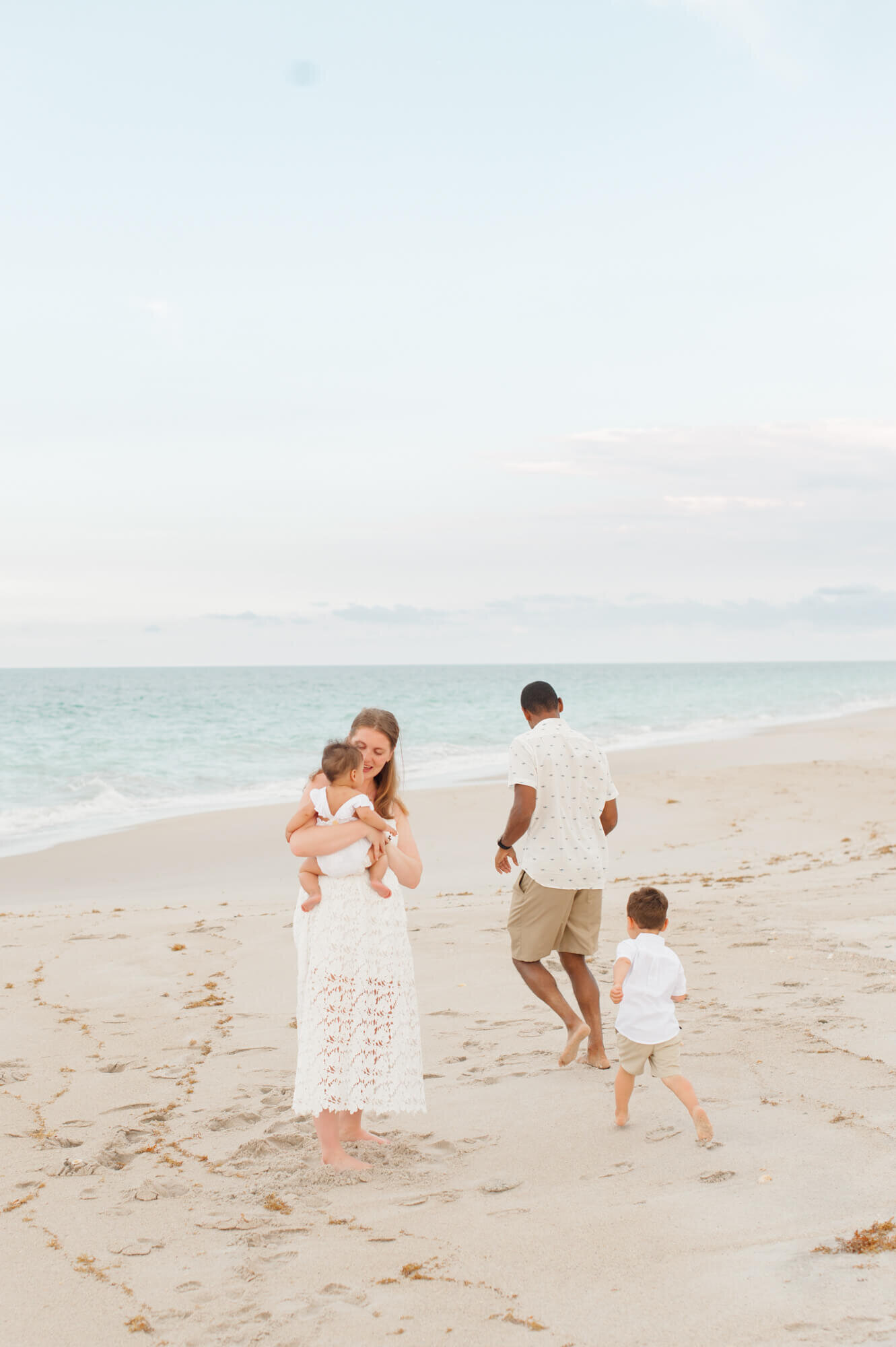 Kissimmee photographer captures family playing on the beach near the waves during family photos