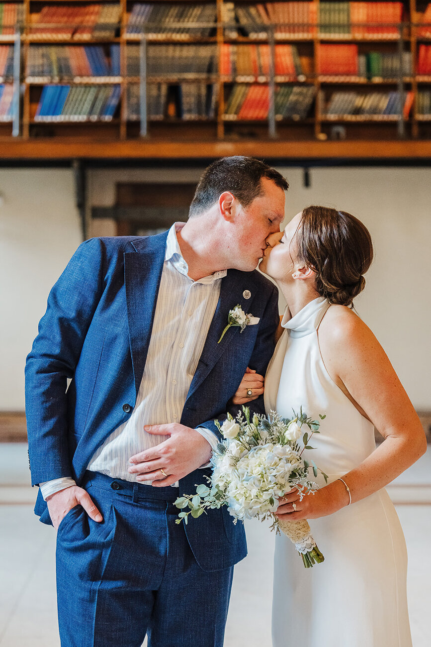 just married couple kiss under book stacks in boston