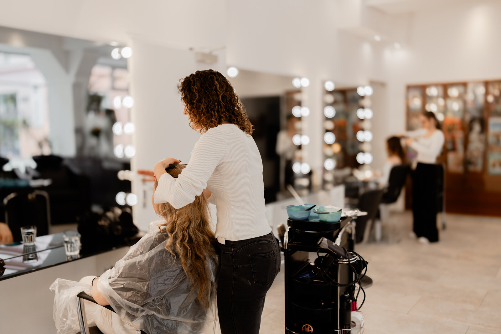 Friseur frisiert ein Mädchen