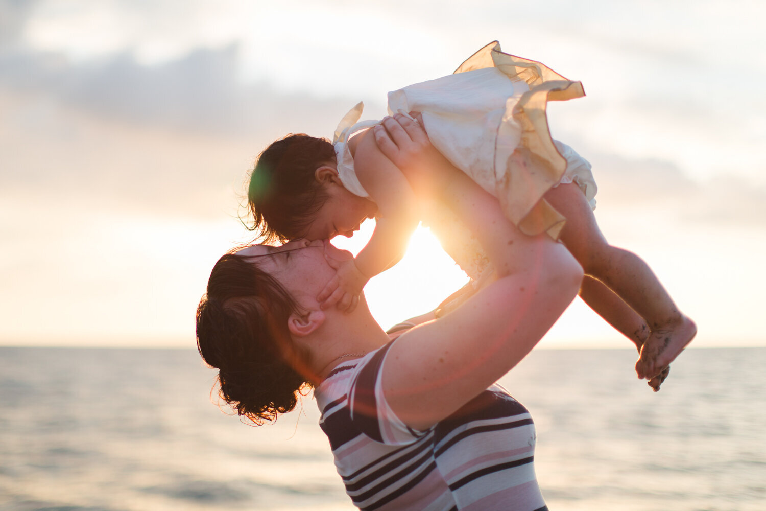 mother lifting up little girl