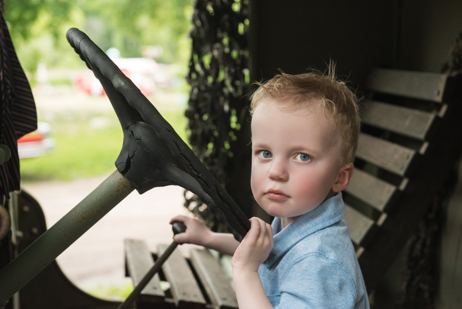 Little boy sitting in old car