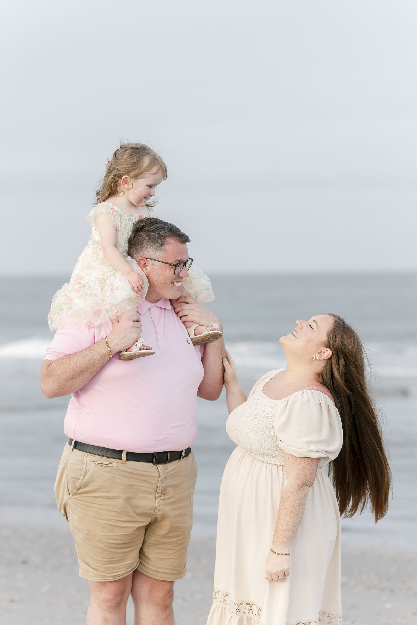family of three standing on ocean city beach photographed by new jersey photographer