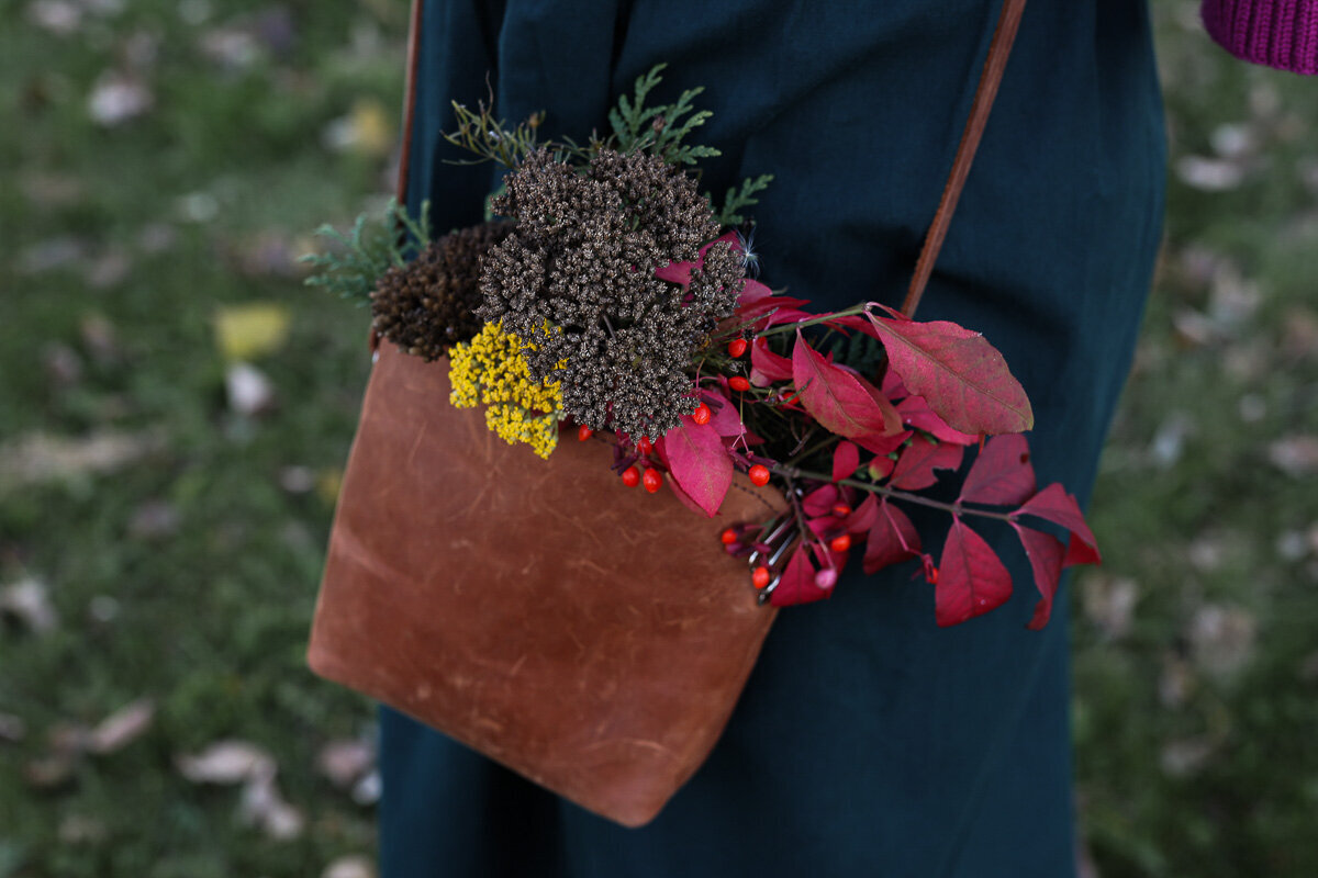 Leather purse with autumn flowers by Yuliia Terziian Photography