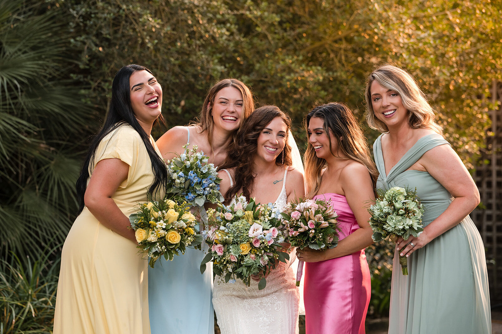 A joyful group of bridesmaids posing outdoors in soft, natural light, captured by CMH Studios during a luxury San Antonio wedding
