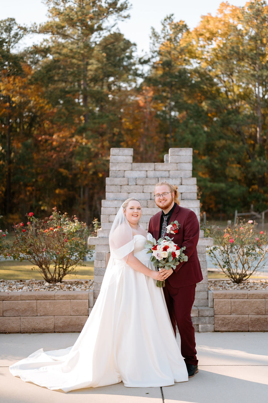 Bride and groom standing in front of a brick post